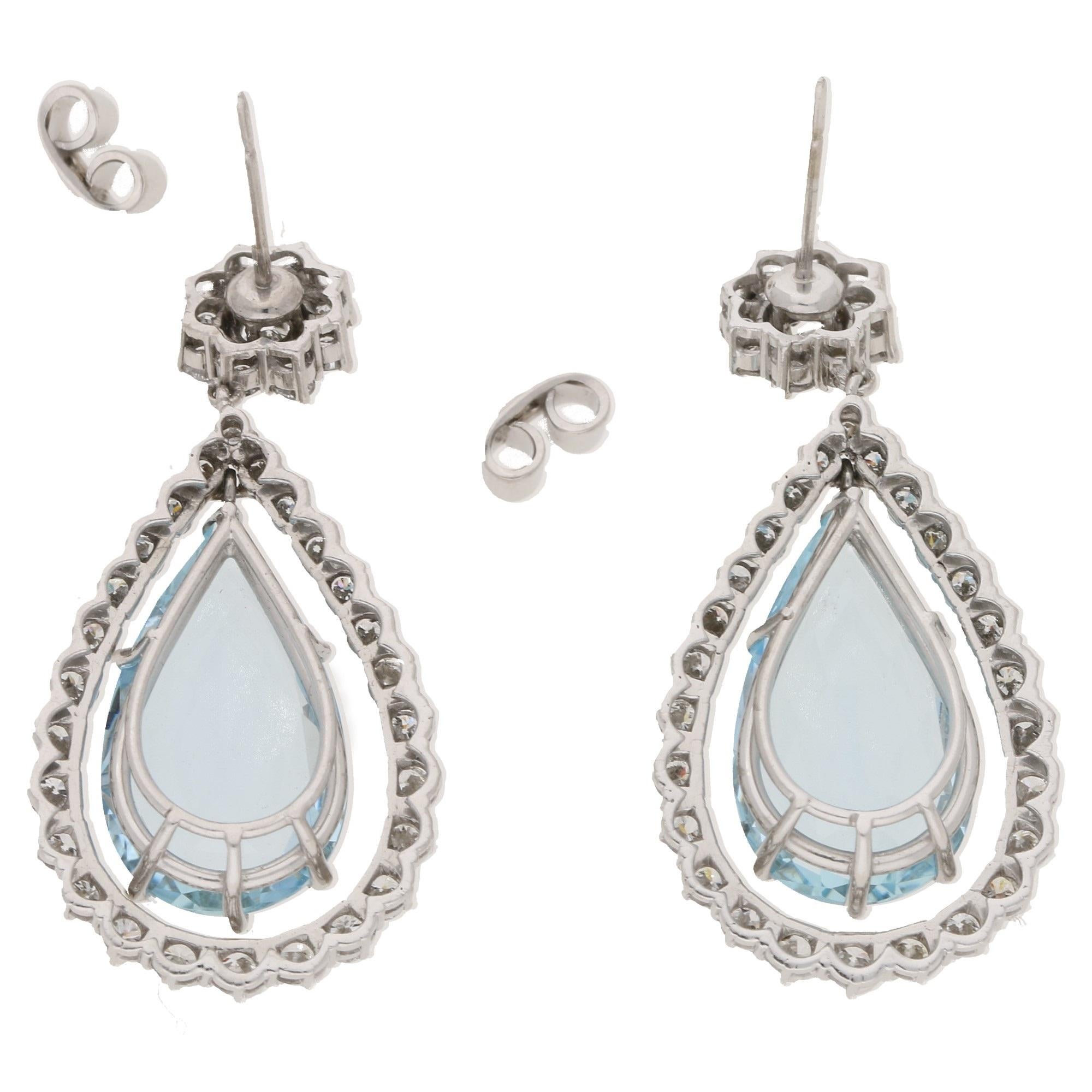 This impressive pair of aquamarine and diamond drop earrings feature the classic round brilliant - cut diamond cluster stud suspending approximately 3 carats of AA pear - shaped aquamarines in each earring, further accented by a graduated floating
