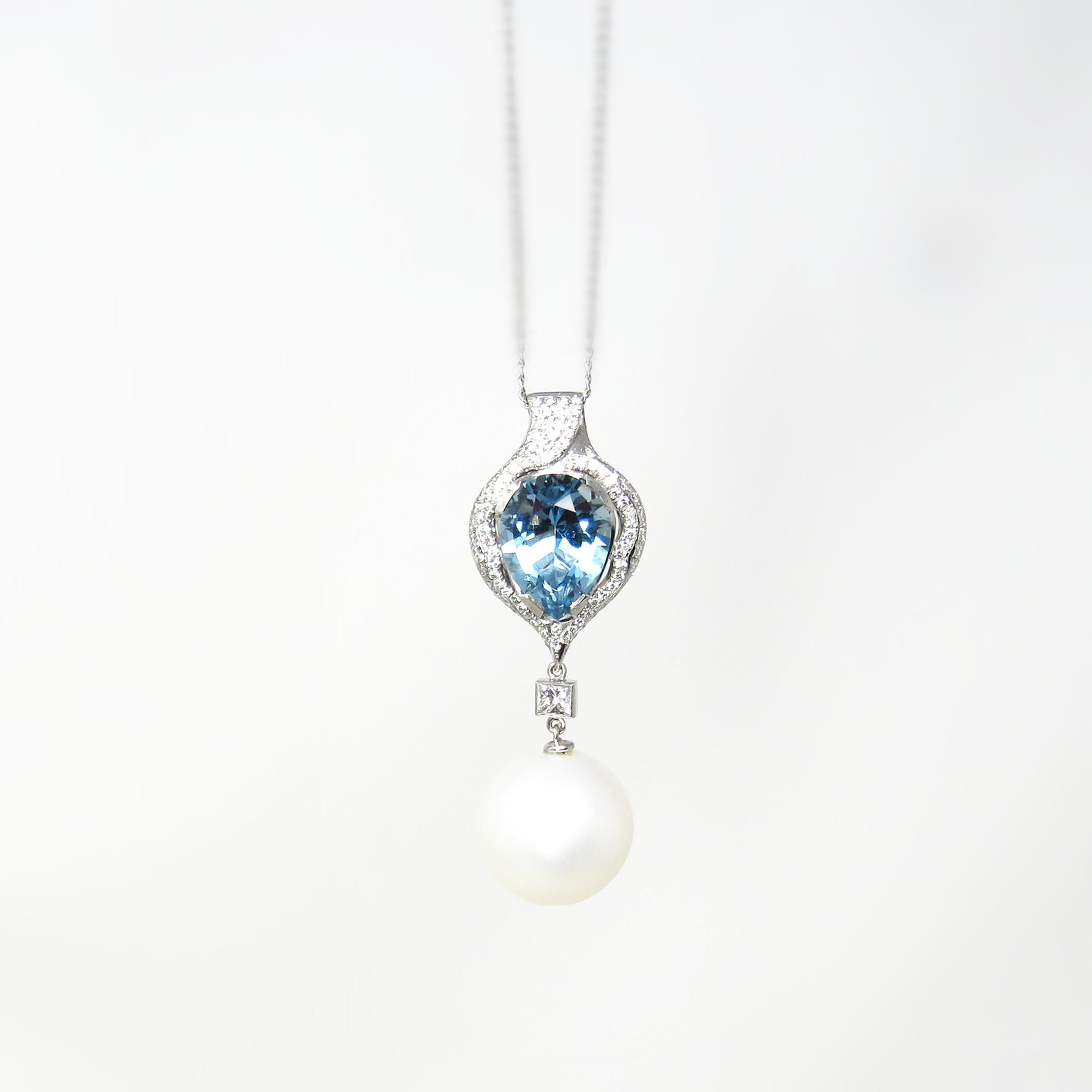 This stunning necklace pendant features a striking blue Aquamarine gemstone that measures about 15.5 x 11.5mm, incased in a halo of diamonds.  Set below the gemstone is a fascinating high luster 17 mm South Seas cultured pearl.

The pendant features