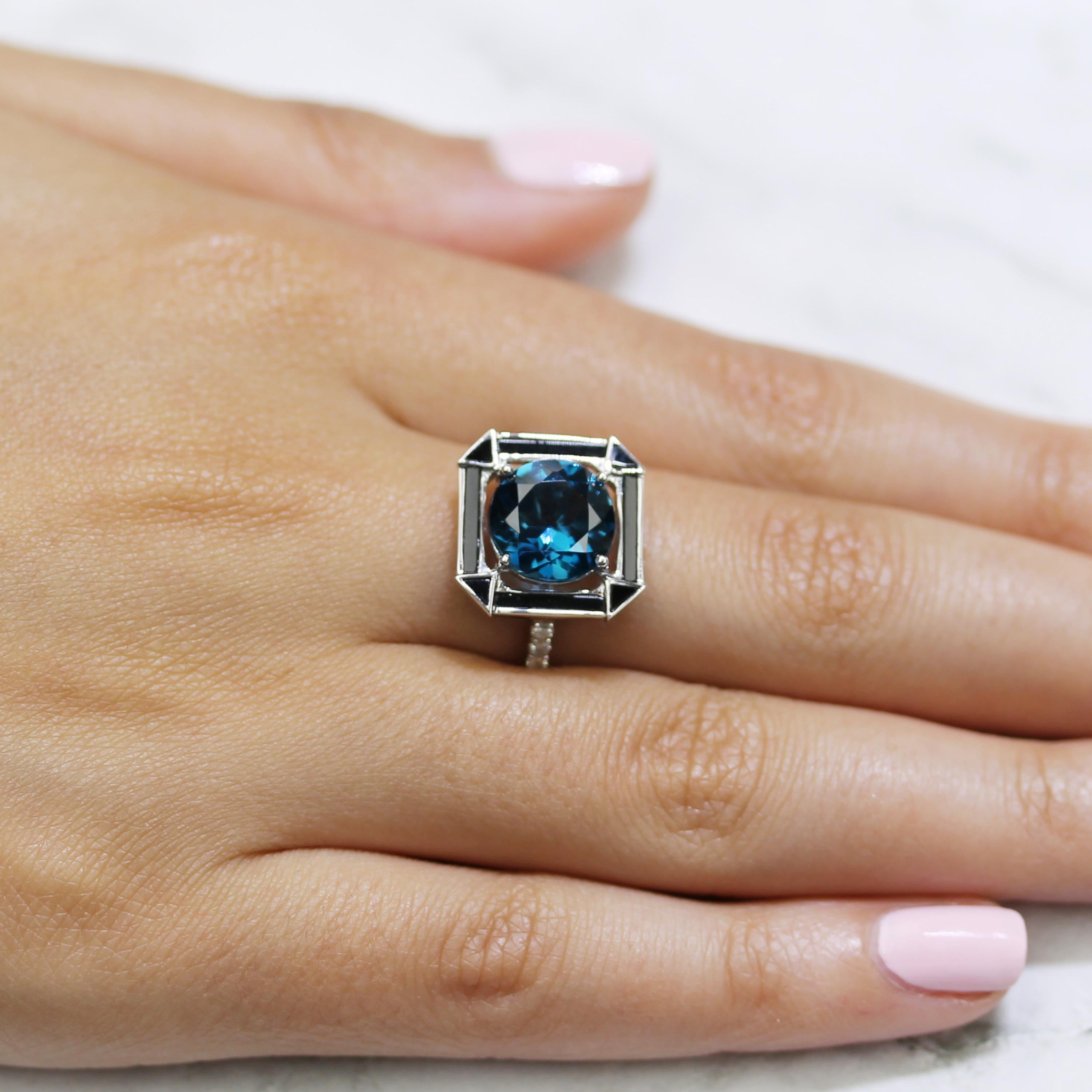 Art-Deco Style Cocktail Ring featuring Round London Blue Topaz, Black Onyx, and Diamonds, set in 18K white gold. Finger size 6.5, adjustable upon request/quote. London Blue Topaz stone used in this ring is natural, untreated, and a deep indigo blue.