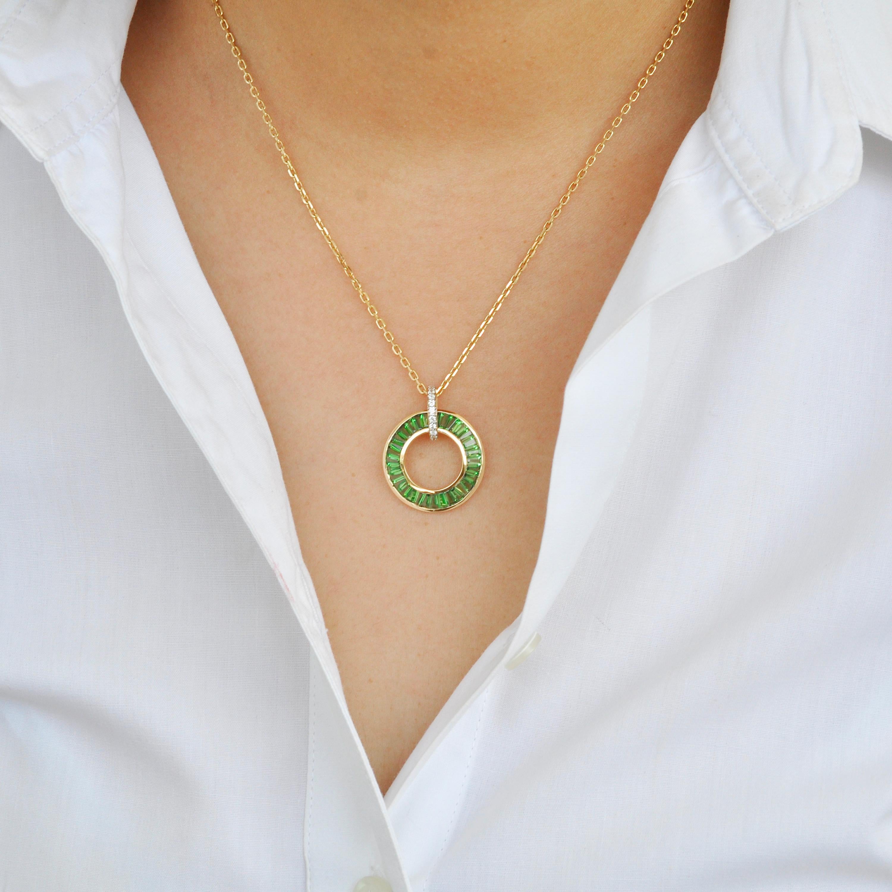Indulge in the timeless allure of this Art Deco-inspired pendant, crafted in exquisite 18 Karat gold. Designed to captivate and enchant, this circular pendant features a stunning arrangement of Tsavorite garnet baguettes, expertly channel set to