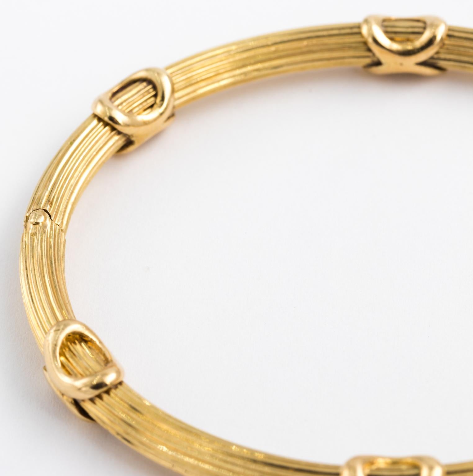 Circa mid-20th century French bangle hallmarked with 18 karat gold. Design is reeded with six x-shaped motifs. The bracelet also comes with safety clasp.
