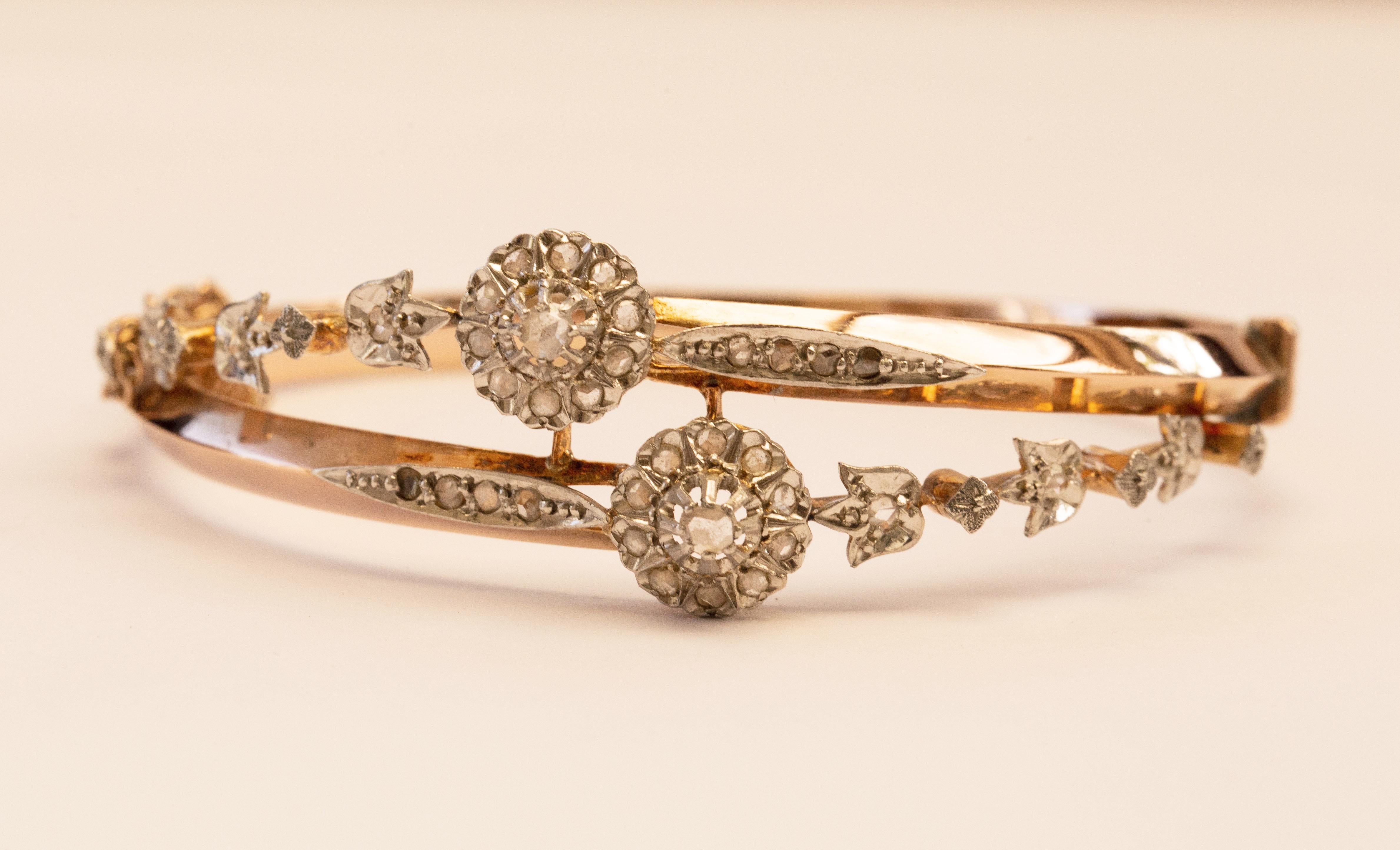 An antique 18 karat yellow gold bangle/rigid bracelet with 36 rose cut diamonds set in platinum manufactured circa 1900, most likely in France. The bracelet features floral decor. The bracelet is delicate, yet eye catching and it would be a great