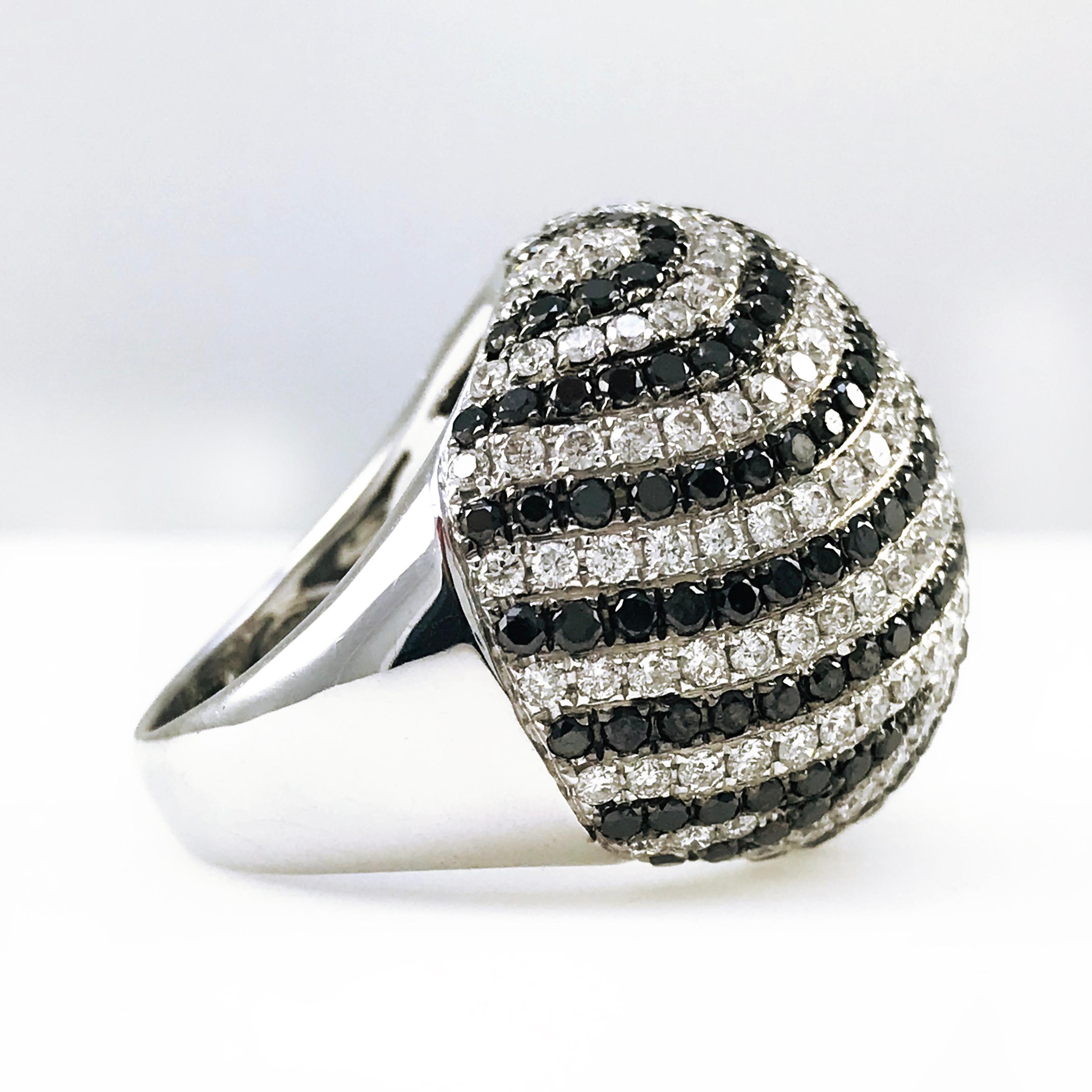 Stunning 18 Karat White Gold, Black and White Pave Set Diamond Dome Cocktail Ring. Rows of semi-circles of white and black round diamonds adorn this significant-sized ring making it a true statement piece. Not to be outdone by the sparkling pave-set