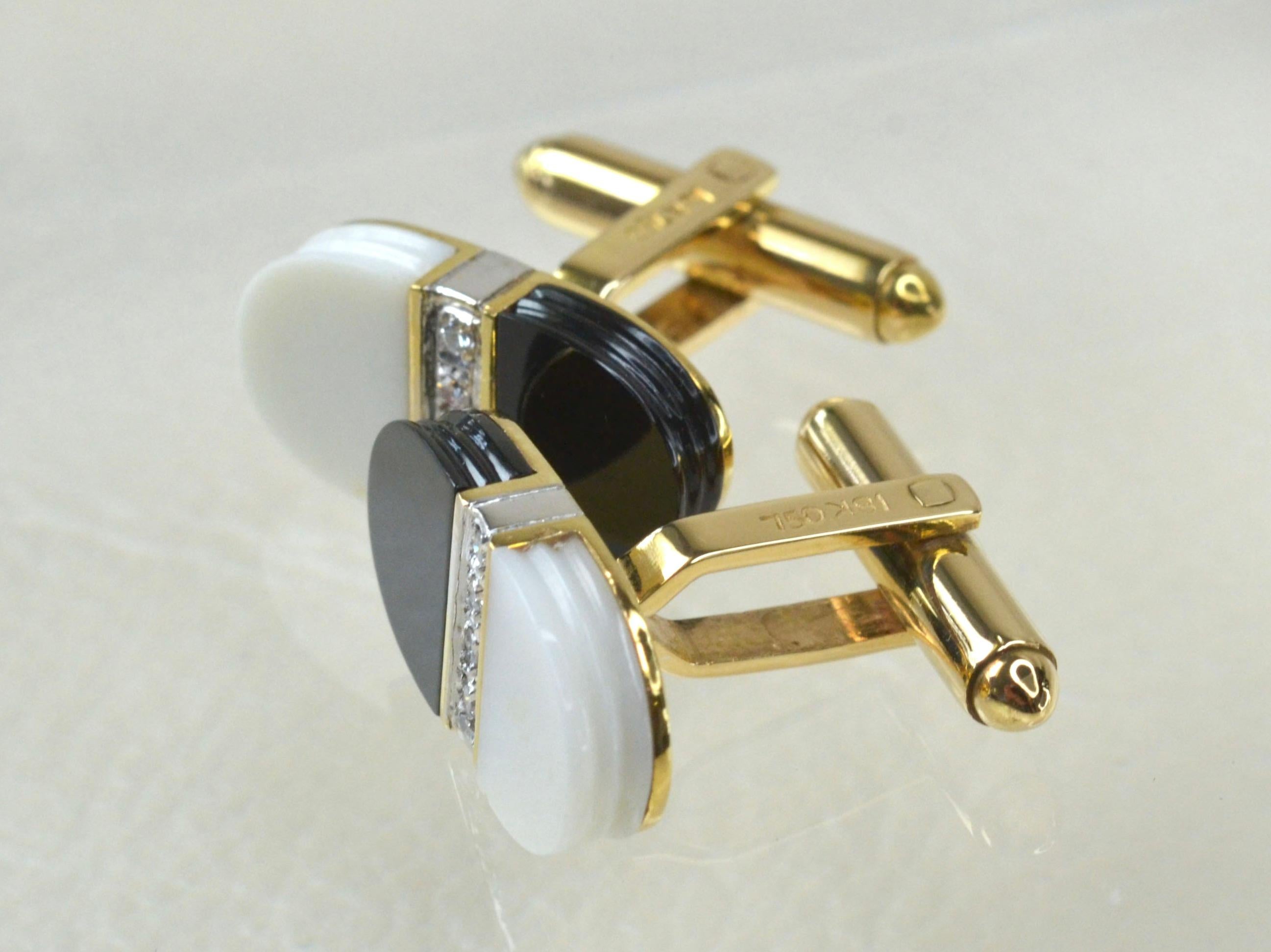 18 Karat Gold 1970er Manschettenknöpfe. Jeder Manschettenknopf besteht zur Hälfte aus schwarzem und weißem glatten Onyx, beide verziert mit vier zentralen weißen Diamanten, gefasst in Weißgold.
Unisex-Schmuck mit kontrastierenden Farben, die durch