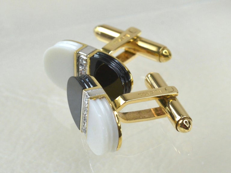 18 Karat Gold 1970s Cufflinks. Each Cufflink is half and half Black and White Smooth Onyx, both decorated with four central White Diamonds, set in White Gold.
Statement unisex jewellery, with contrasting colours highlighted by yellow gold. 

The