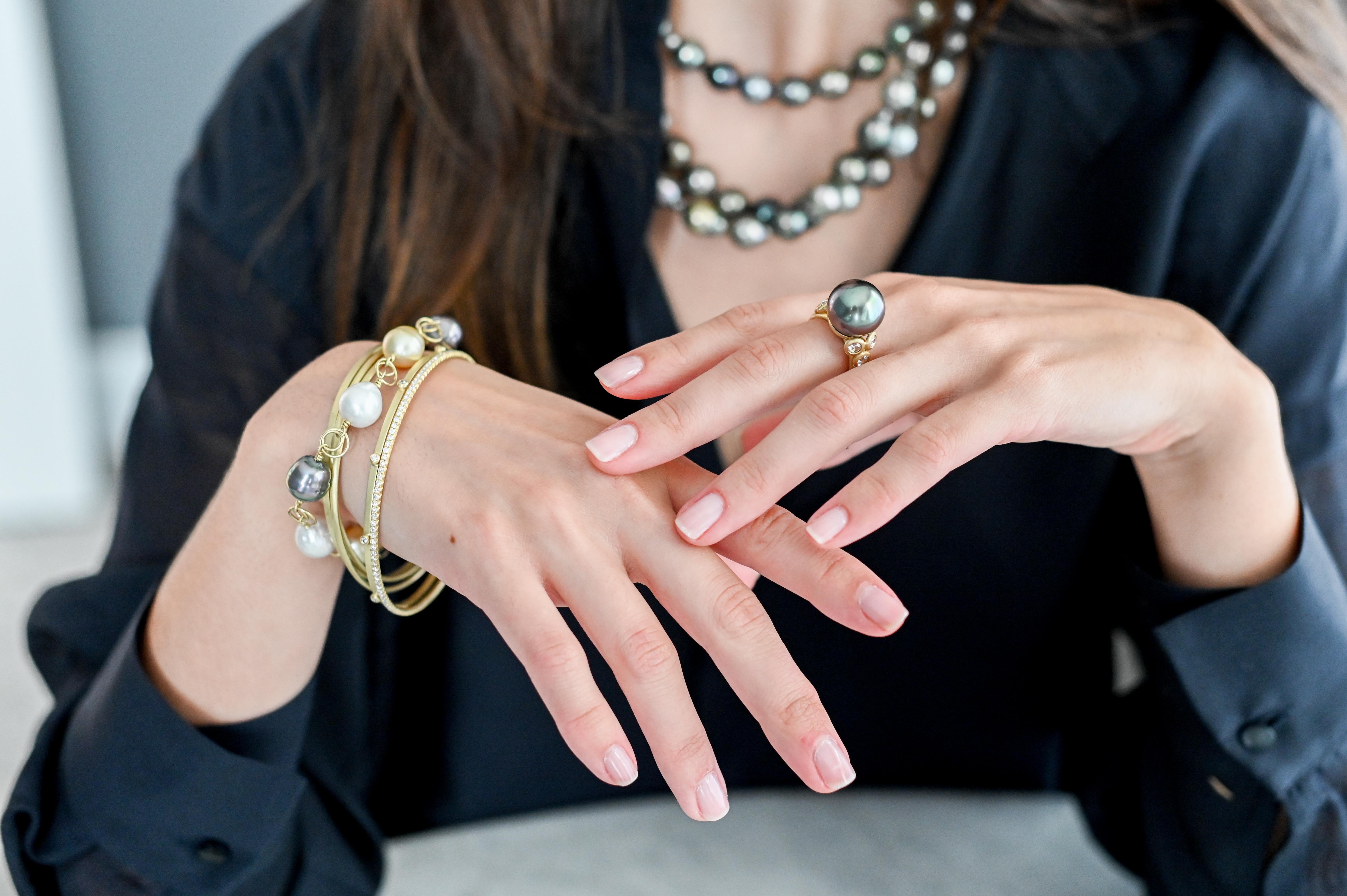 Faye Kim's 18k gold Black Tahitian cultured pearl ring with white rose cut diamond accents. Beautiful color, size, and luster with triple diamond accents. Sophisticated and timeless!

Pearl: 14.5mm
Diamonds: .80 Carats twt
Size 7 (Can be sized)