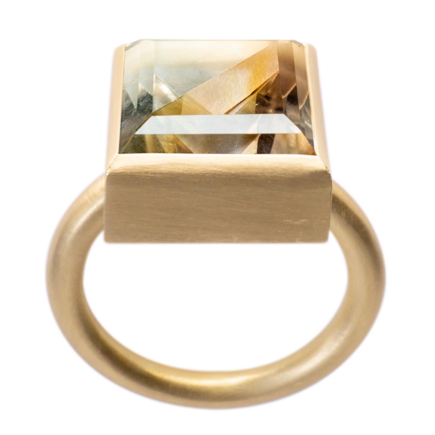 This bold and minimal statement ring is a modern take on the cocktail ring. It features a stone that is fashioned from two natural colored stones that have been fused together then cut and polished as one. When the two characteristics of the