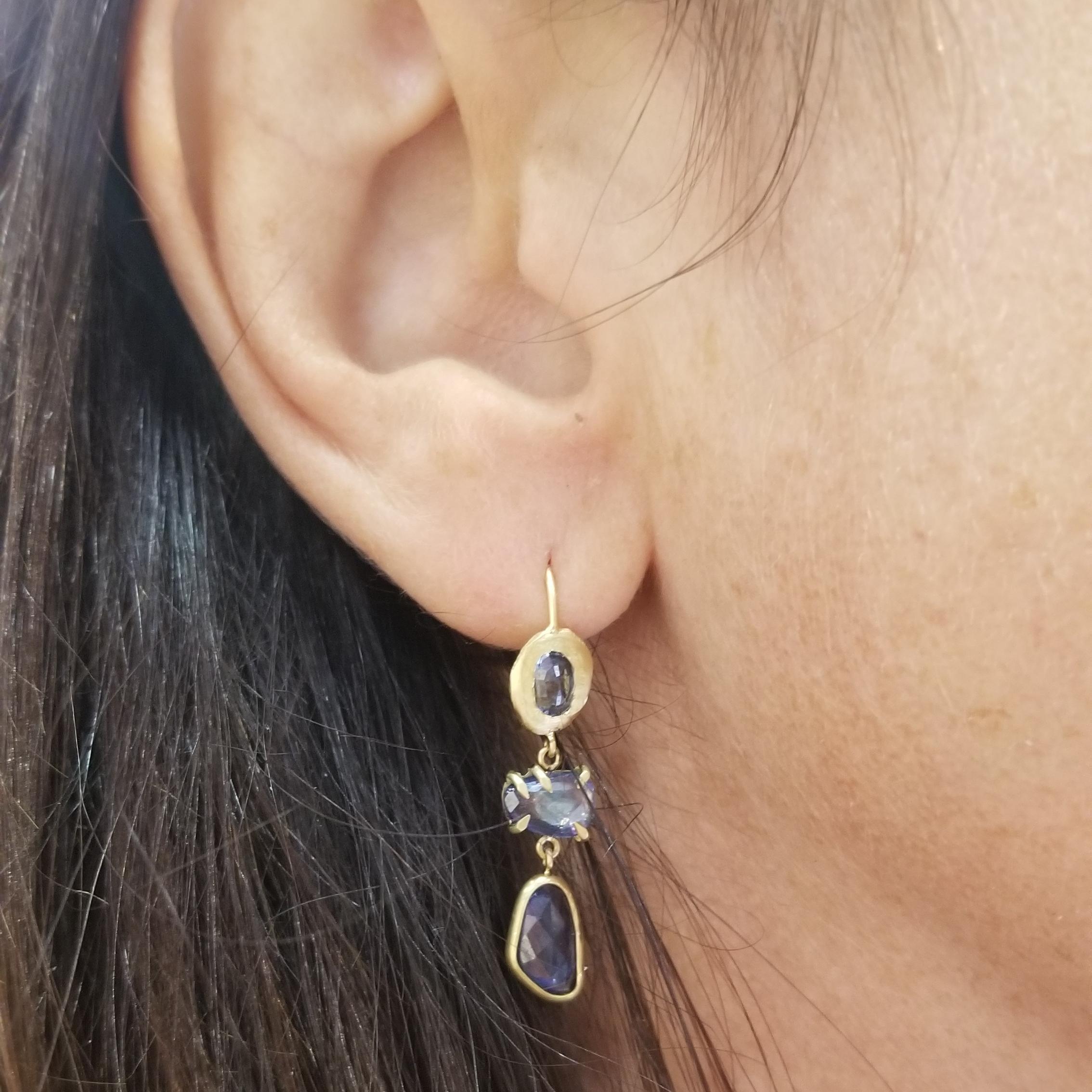 18KT gold blue sapphire earrings, featuring prong and bezel set one of a kind sapphires with french hooks. Handmade by NYC artist Page Sargisson, this style is one of her best sellers.
