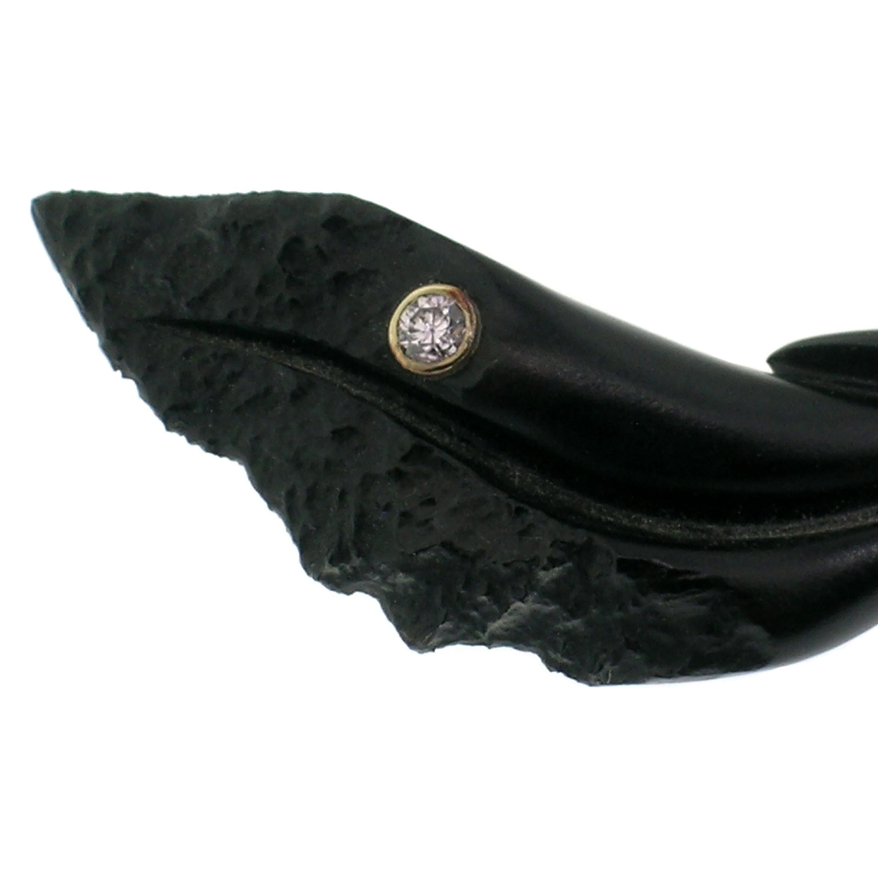 This natural black chalcedony sculpture, carved by renowned American lapidary master Steve Walters, features elegant carving contrasted with a rough stone texture. The sinuous sculpture is set with an exceptional cabochon of Oregon Sunstone which