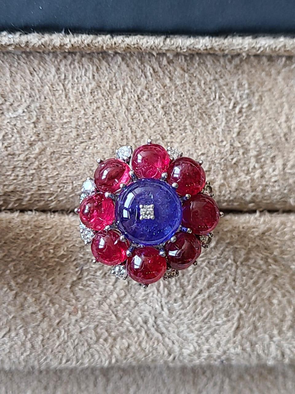 A very cute and dainty, art deco style Spinel and Tanzanite Cocktail Ring set in 18K Gold & Diamonds. The Spinel cabochon, weighing 10.19 carats, and is completely natural without any treatment. The weight of the Tanzanite cabochons is 27.01 carats