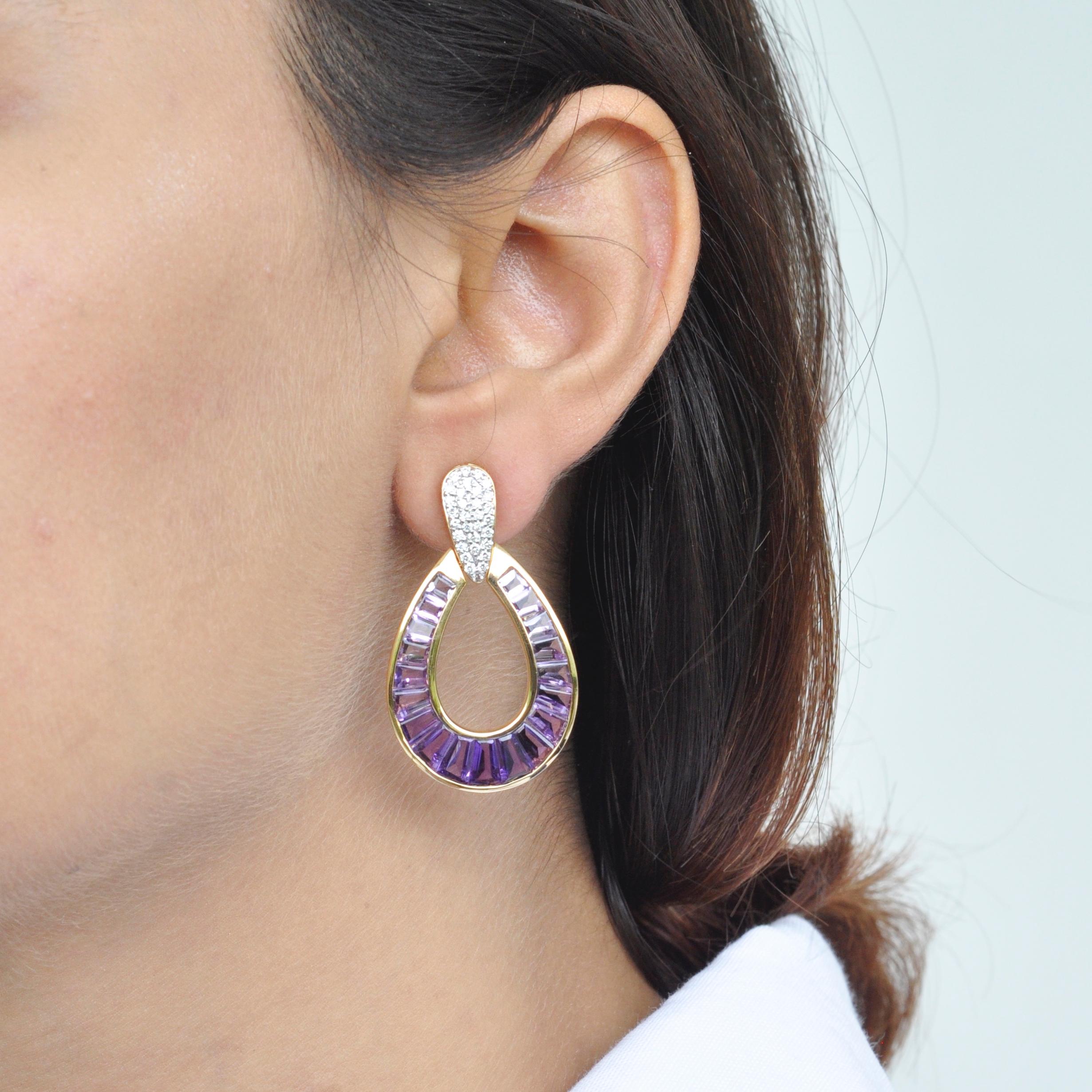 Art, color and culture all come together to inspire this 18 karat gold calibre cut amethyst taper baguette diamond dangling raindrop earrings, where dégradé (gradient) hues of amethyst exudes royalty and luxury while dictating the movement of eye.