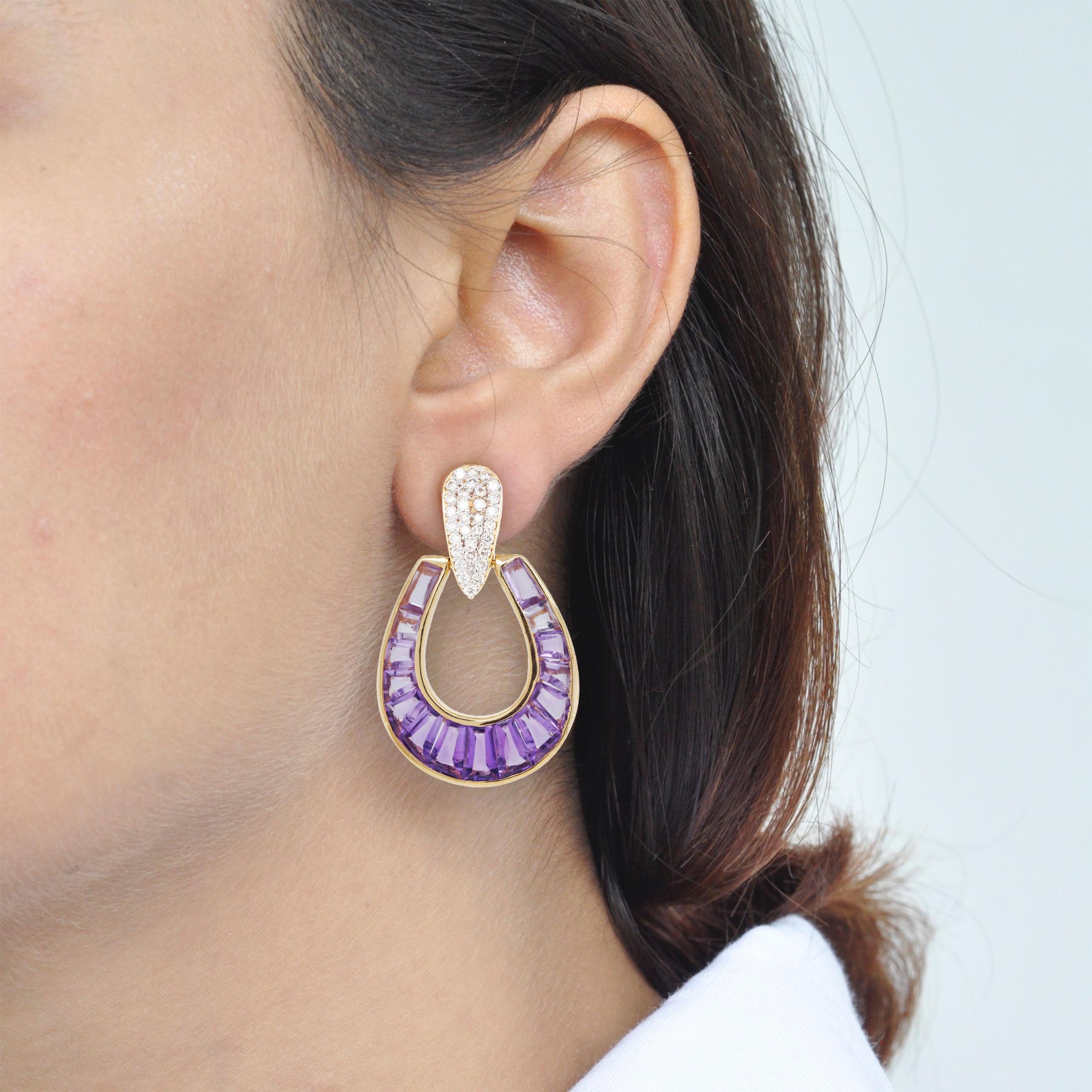 Art, color and culture all come together to inspire this 18 karat gold calibre cut amethyst taper baguette diamond dangling raindrop earrings, where dégradé (gradient) hues of amethyst exudes royalty and luxury while dictating the movement of eye.