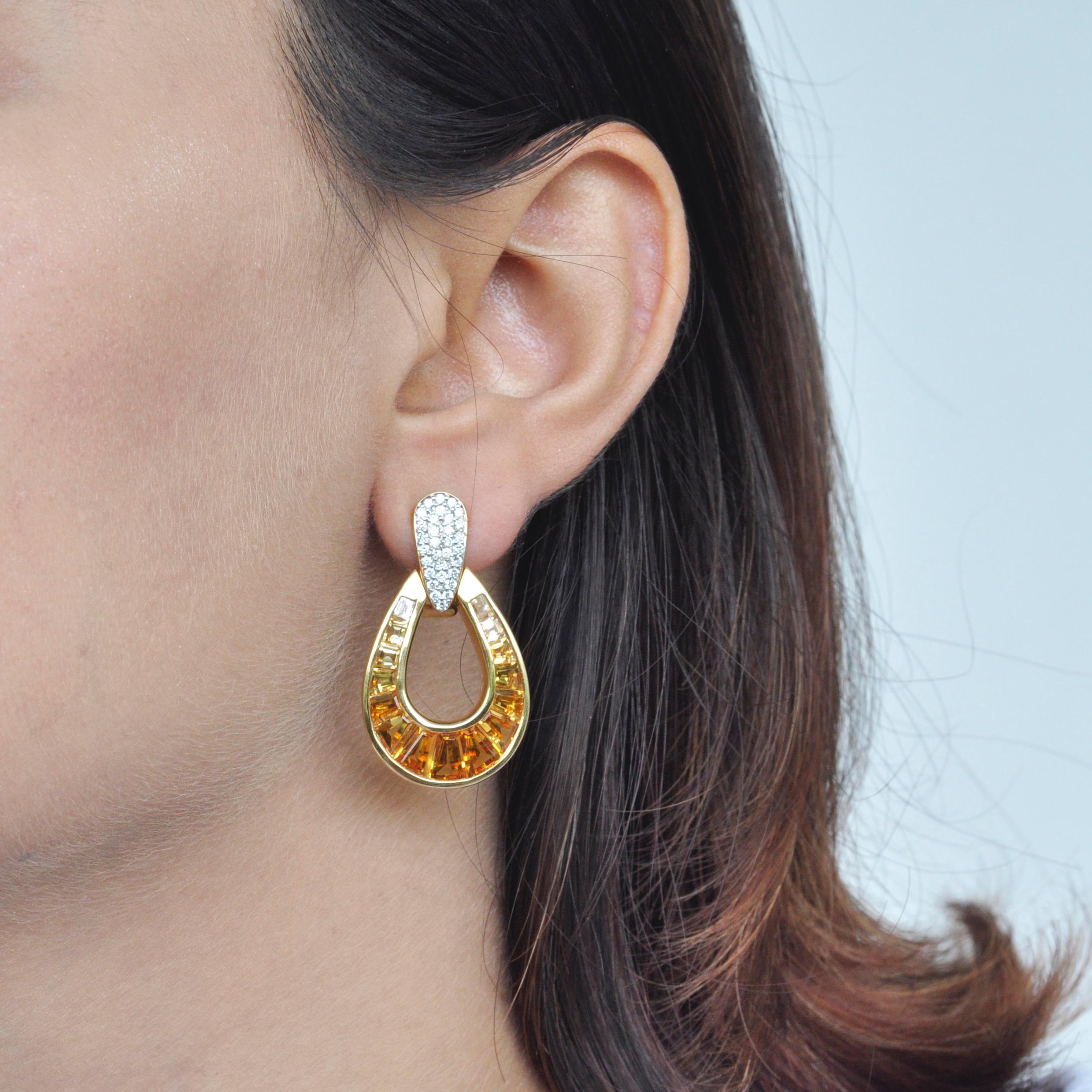 Art, color and culture all come together to inspire this signature calibre cut citrine taper baguette with diamond top dangle doorknocker earrings in 18 karat gold, where dégradé (gradient) hues of citrine exudes happiness and optimism while