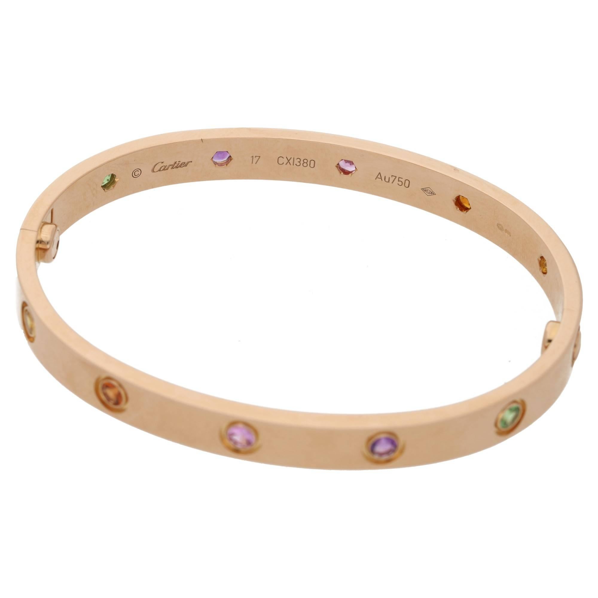 A vibrant 18k rose gold, coloured stone set Cartier bracelet from the Love collection. The bracelet is set with 10 coloured gemstones throughout, including amethyst, yellow sapphires, pink sapphires and green and orange garnets. The bracelet