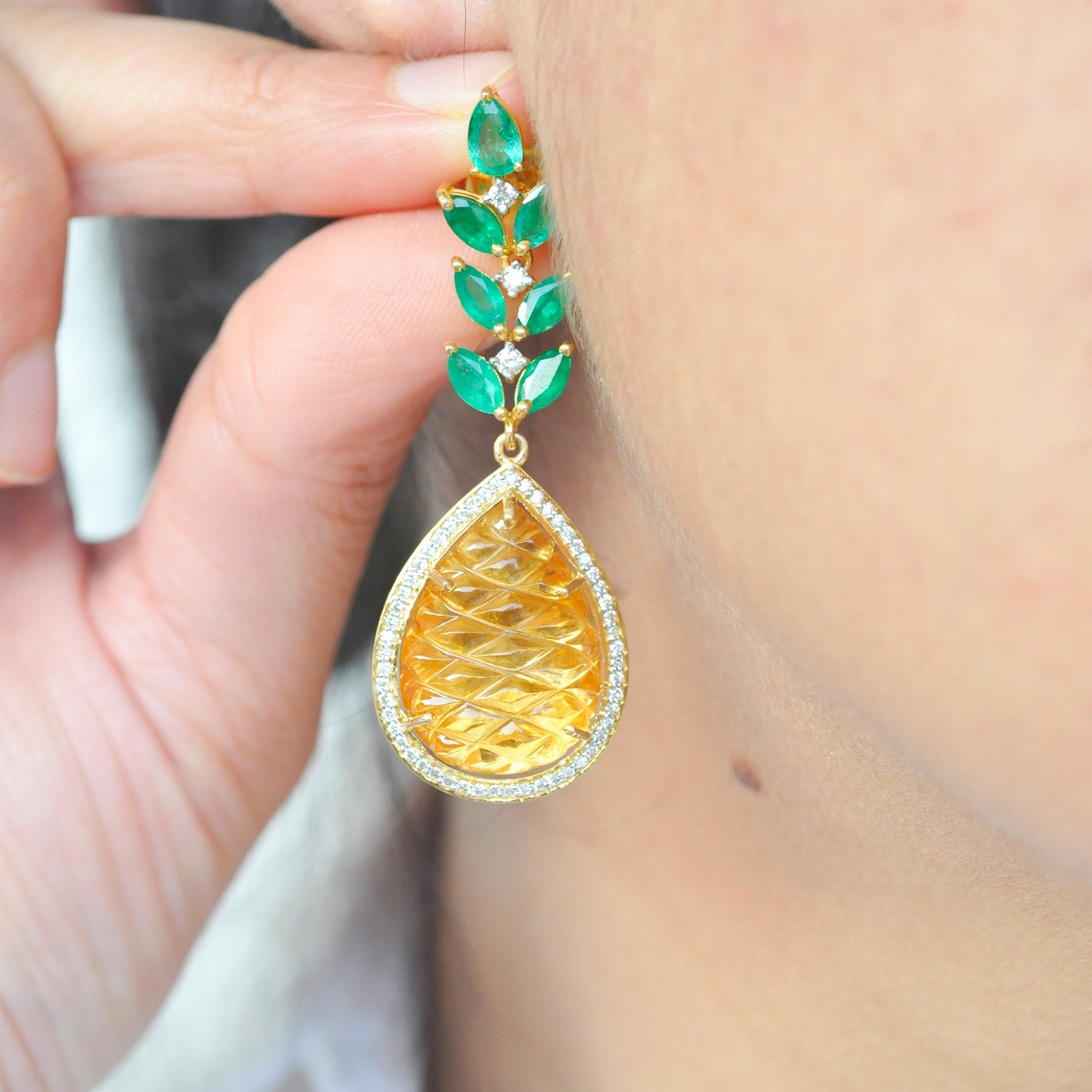 18 karat gold carved citrine emerald diamond pineapple dangle earrings.

Elegance at its best, these hand-carved pineapple cut pear shaped citrine carvings are accentuated with diamonds and emeralds, set in 18K yellow gold. The citrine carving gives