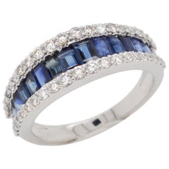Anello a fascia contemporaneo in oro 18 carati con zaffiro blu incastonato e diamante a baguette