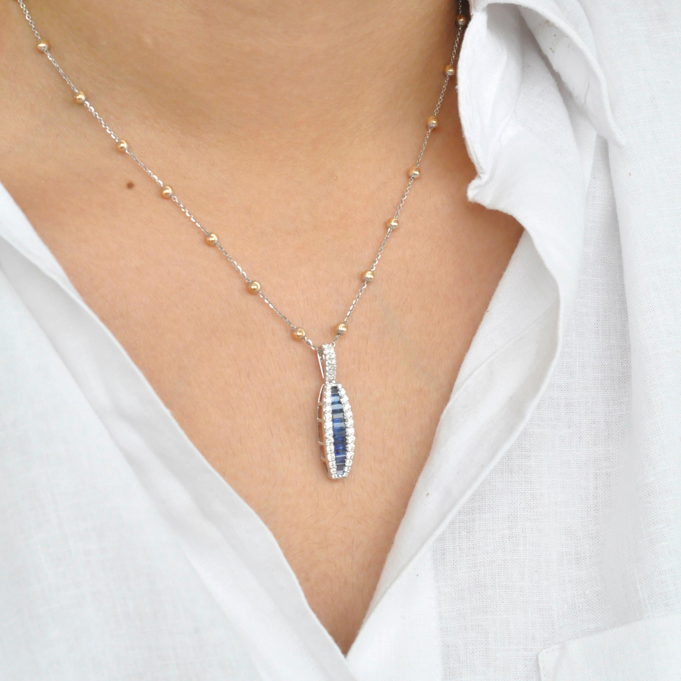 18 karat white gold channel set blue sapphire baguette diamond linear pendant necklace.

The enchanting pendant with the natural blue sapphires incorporated within an equivalent layer of micro pave set diamonds on either is distinctive in its very
