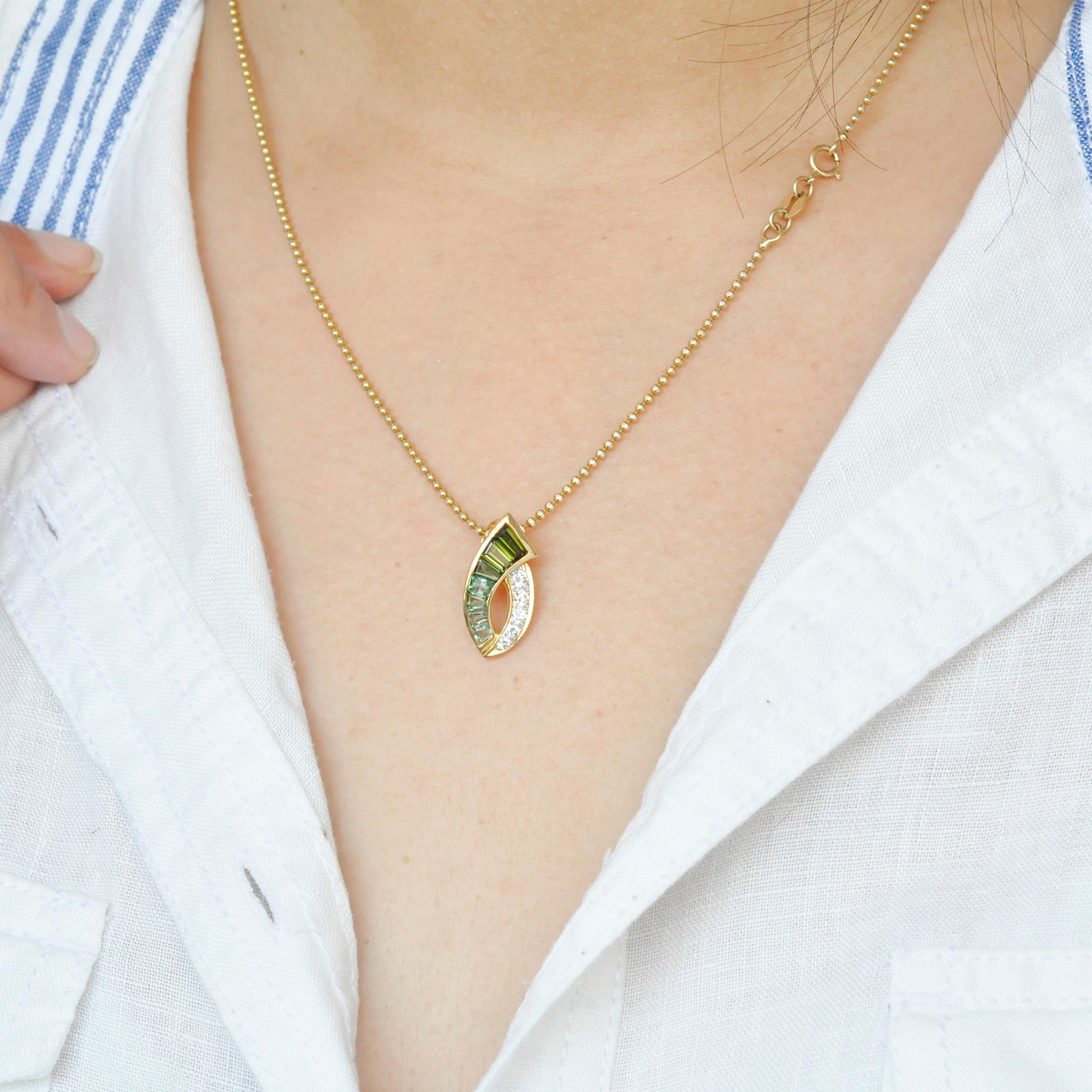 18 karat gold channel set green tourmaline baguette diamond pendant necklace. 

This elegant chic gradient green tourmaline pendant is made in 18 karat yellow gold. The beauty of this pendant lies in the simplicity yet the piece is made with