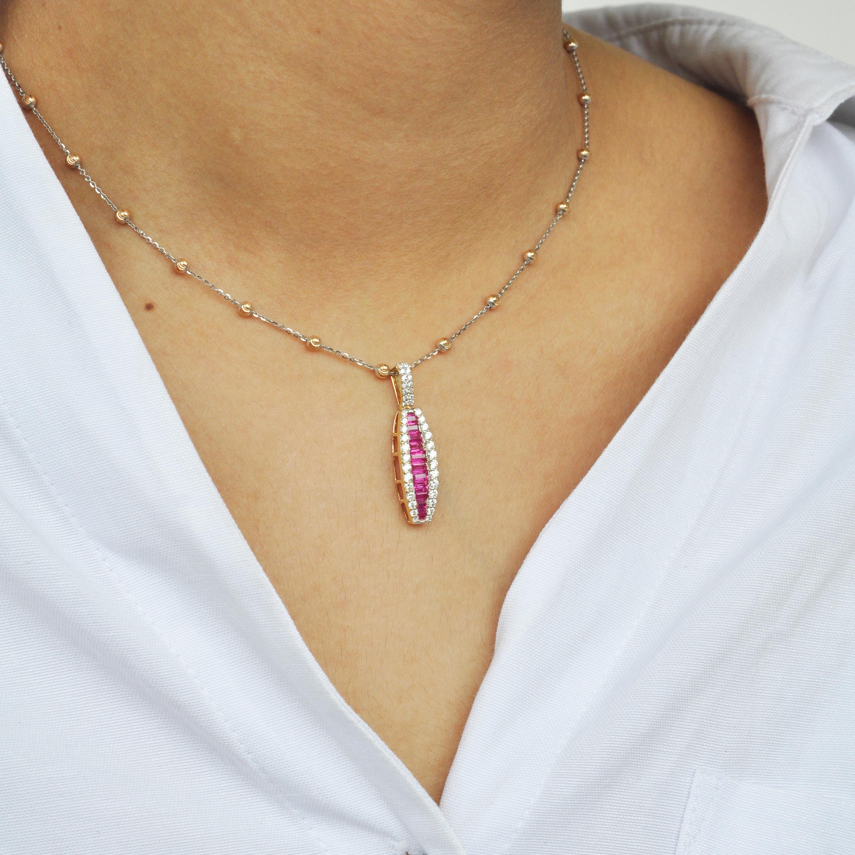 18 karat yellow gold channel set ruby baguette diamond linear pendant necklace.

The enchanting pendant with the pinkish red rubies incorporated within an equivalent layer of micro pave set diamonds on either is distinctive in its very form. The