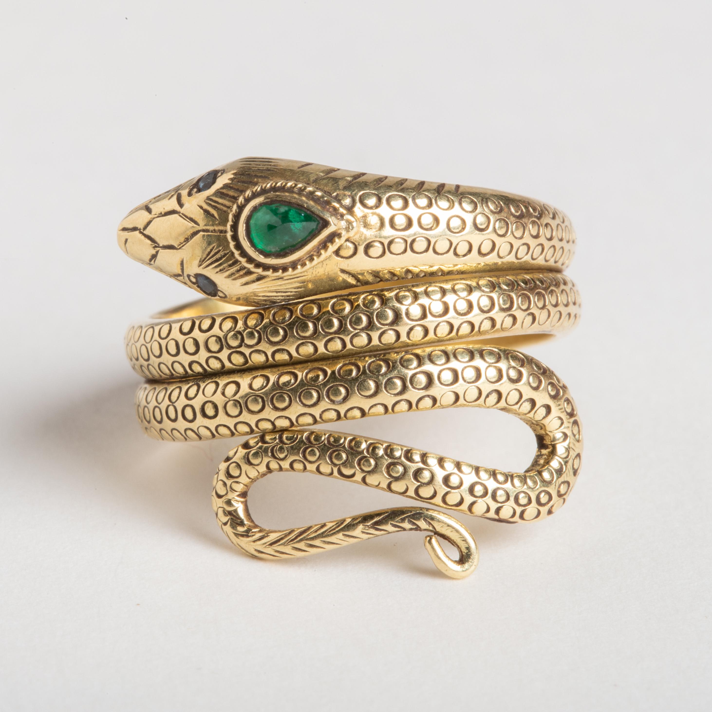 Ein feiner, handgefertigter Ring aus 18 Karat Gold mit einer gewundenen Schlange. Mit einem facettierten, birnenförmigen Smaragd als drittes Auge und facettierten blauen Saphiraugen.  Der Körper des Rings hat fein ausgearbeitete Schuppendetails mit