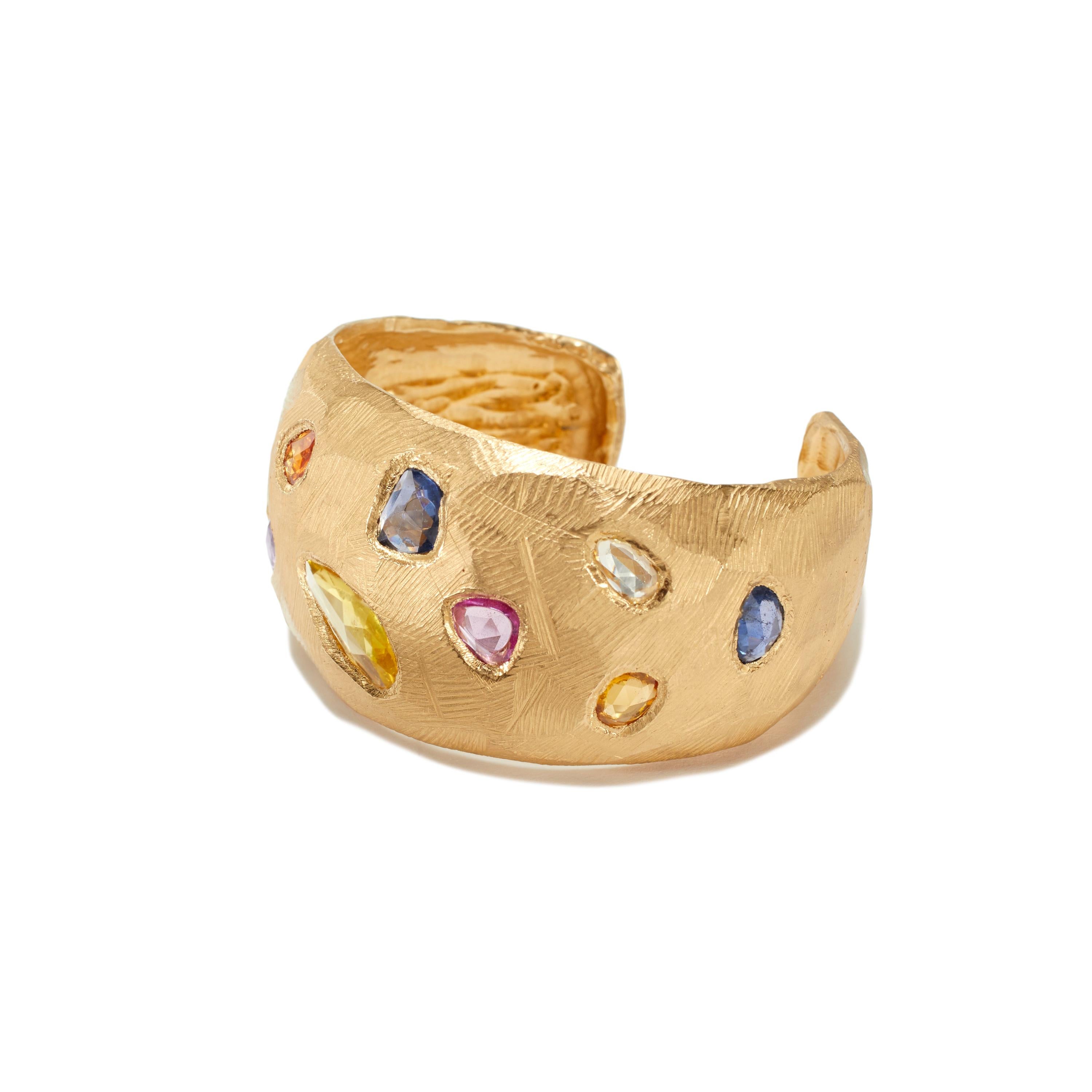 One of a kind handmade 18KT Gold Cuff Bracelet handcarved in New York by artist Page Sargisson.  13.05 carats worth of yellow, blue and pink sapphires in this piece.

This cuff bracelet is on the smaller side and fits a 6.5-7.5