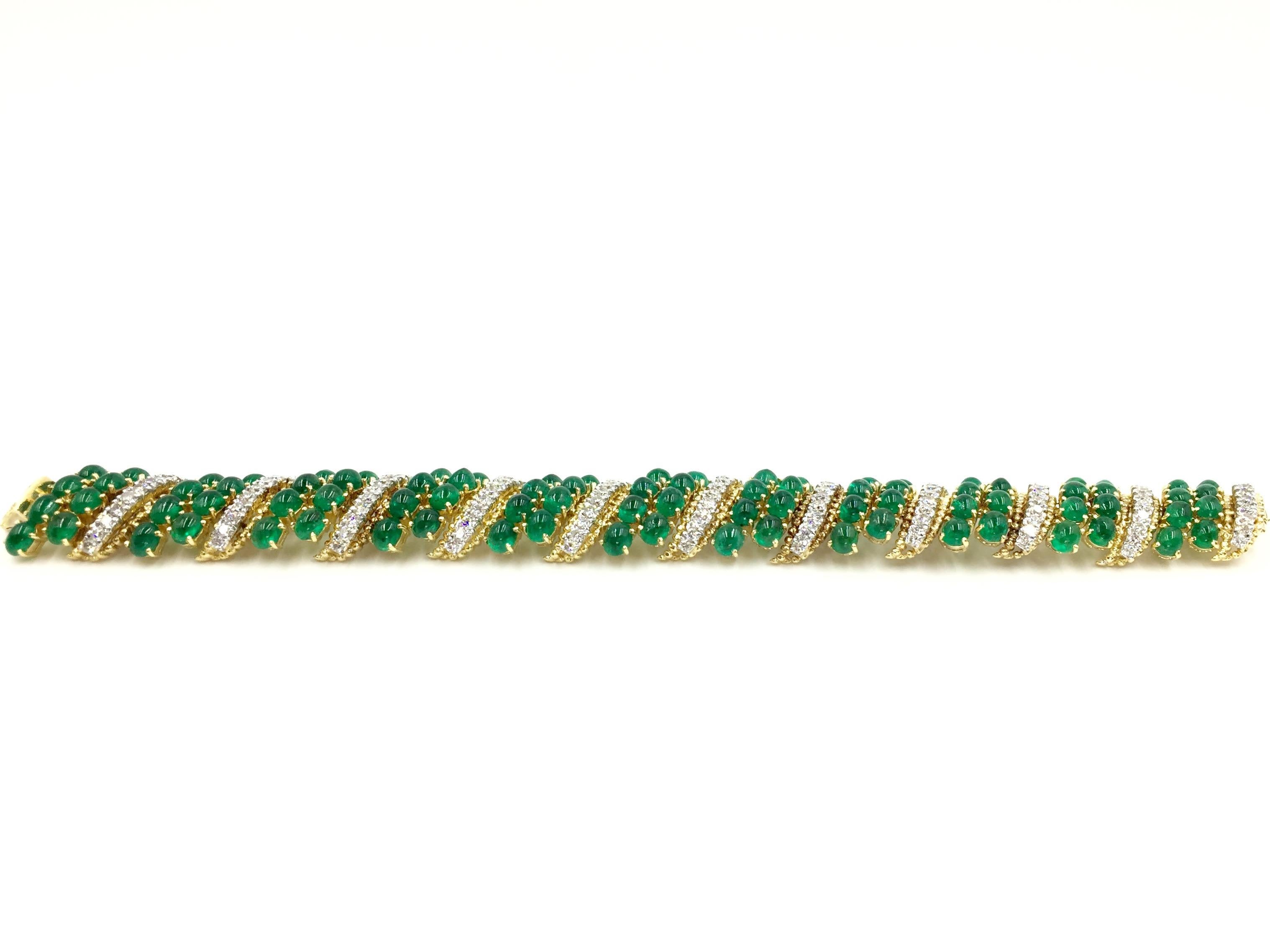 This wide bracelet is designed with beautiful craftsmanship using 4.55 carats of round brilliant diamonds and 36.56 carats of genuine cabochon emeralds. Emeralds have a rich, vivid green tone. Diamonds have an approximate color F and clarity VS2 and