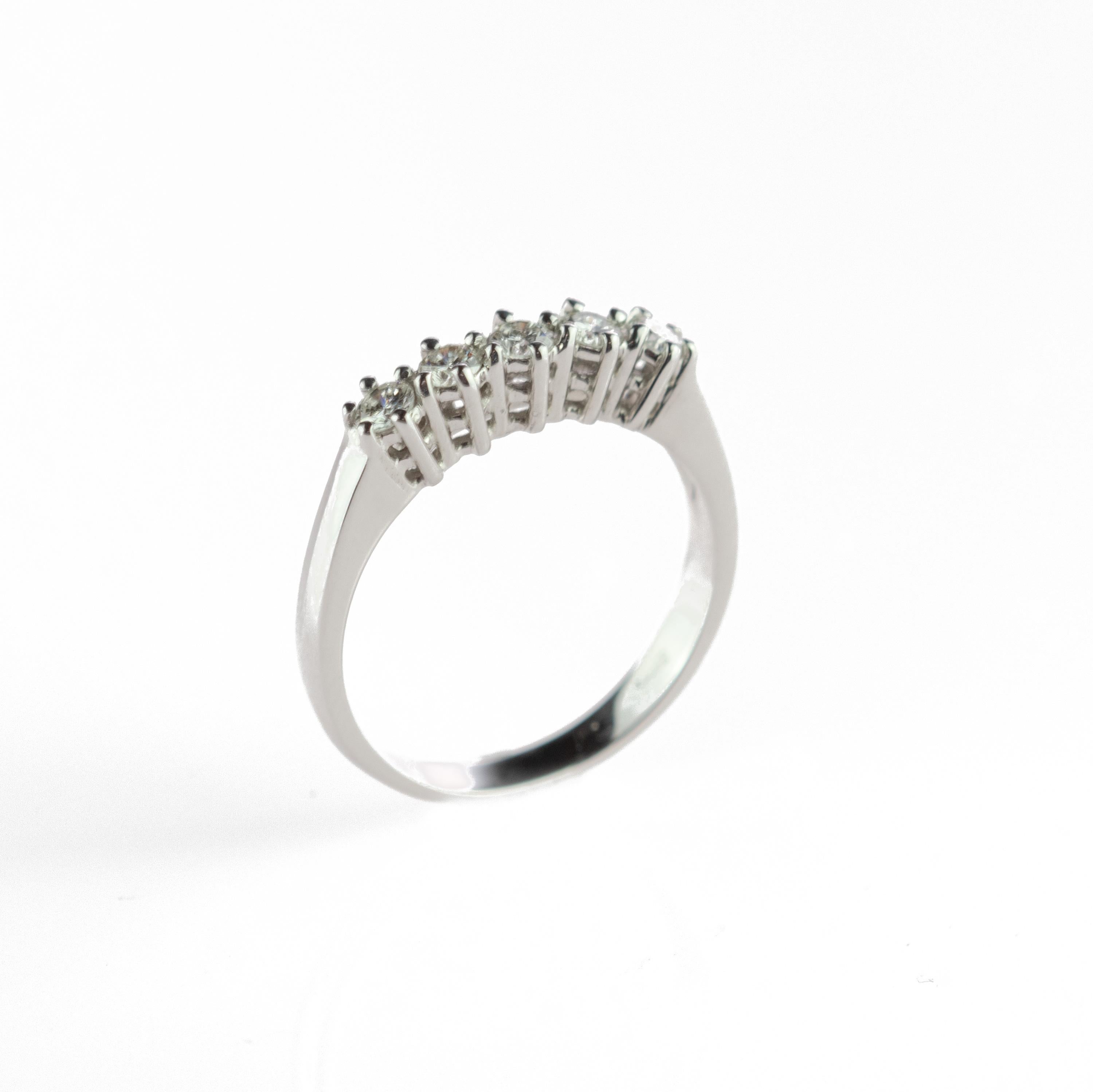 Stunning and marvelous brilliant cut diamond ring embellished by 18 karat carved white gold. Five diamonds for a total of 0.45 carat create a line of gems crafted carefully to be as delicate as the band design. An engagement, bridal or wedding ring