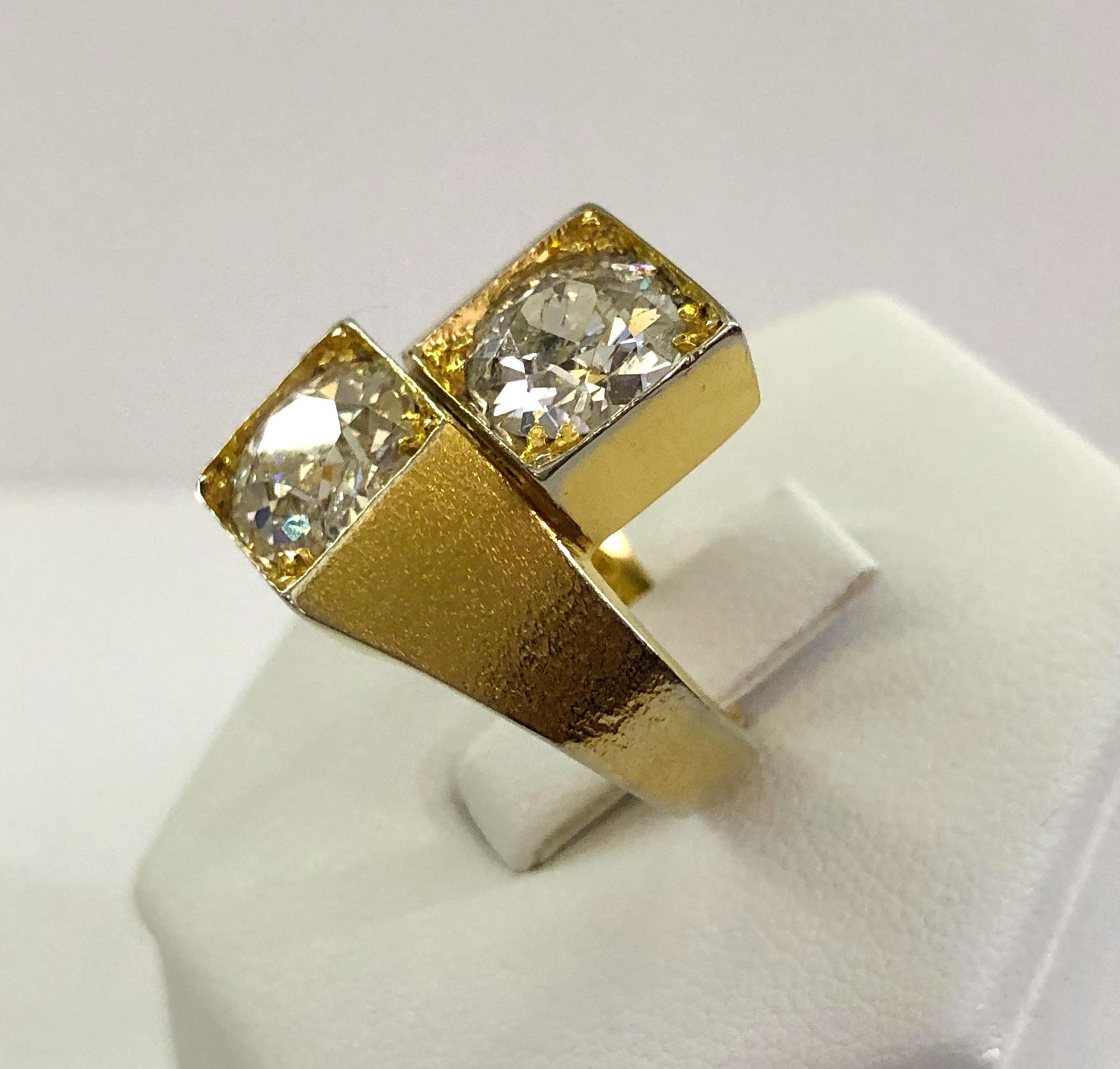 Vintage 18 karat gold ring, with 2 large diamonds of 1.5 karats each (one slightly chipped) in old mine cut, Italy 1970s
Diamond color J/K
Diamond clarify VS1
Ring size US 5
