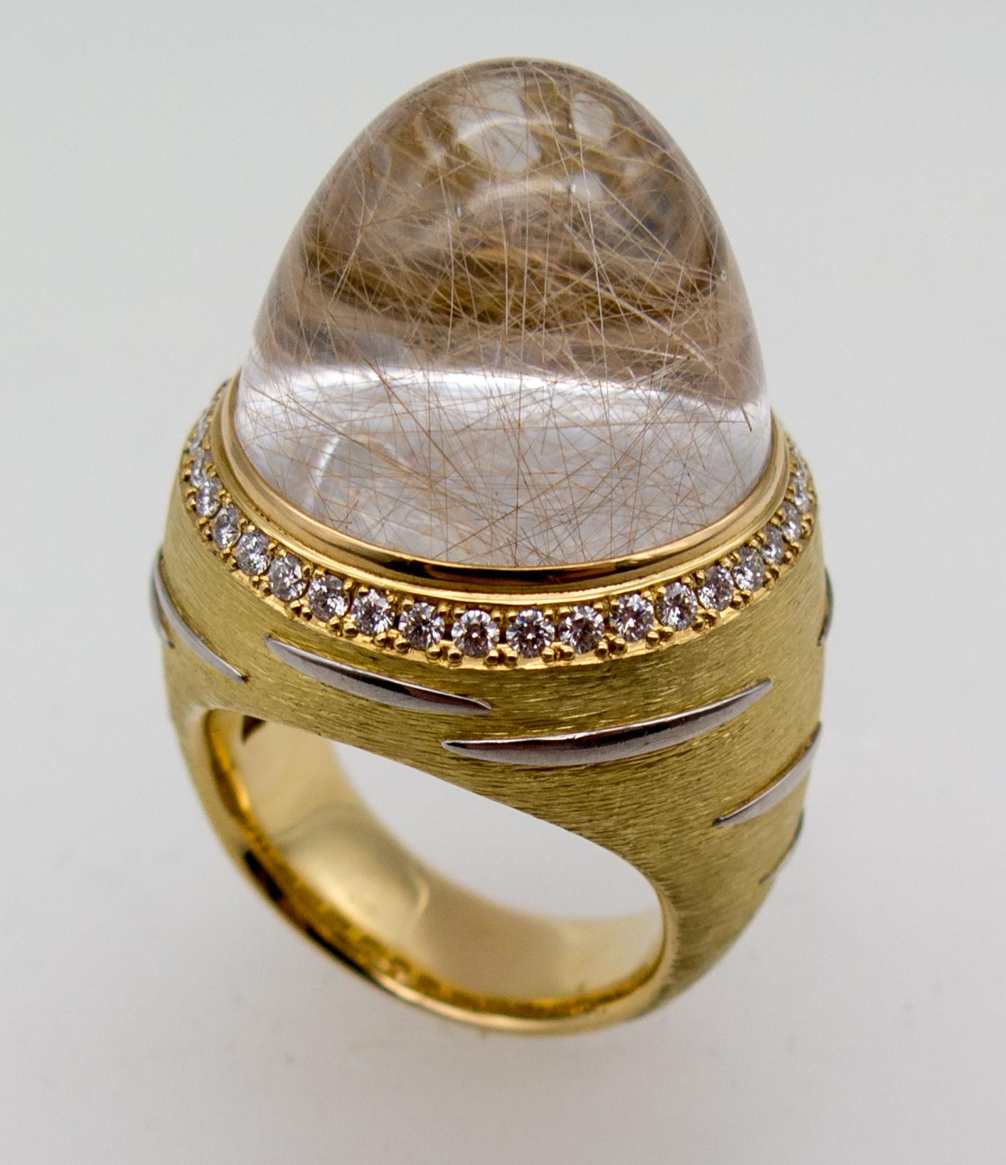 An eye catching and unusual dinner ring featuring a huge dome of rutilated quartz.   it looks like threads floating through vodka or gin, and in fact, it's threads of rutile needle inclusions floating in a suspension of crystal created underground 