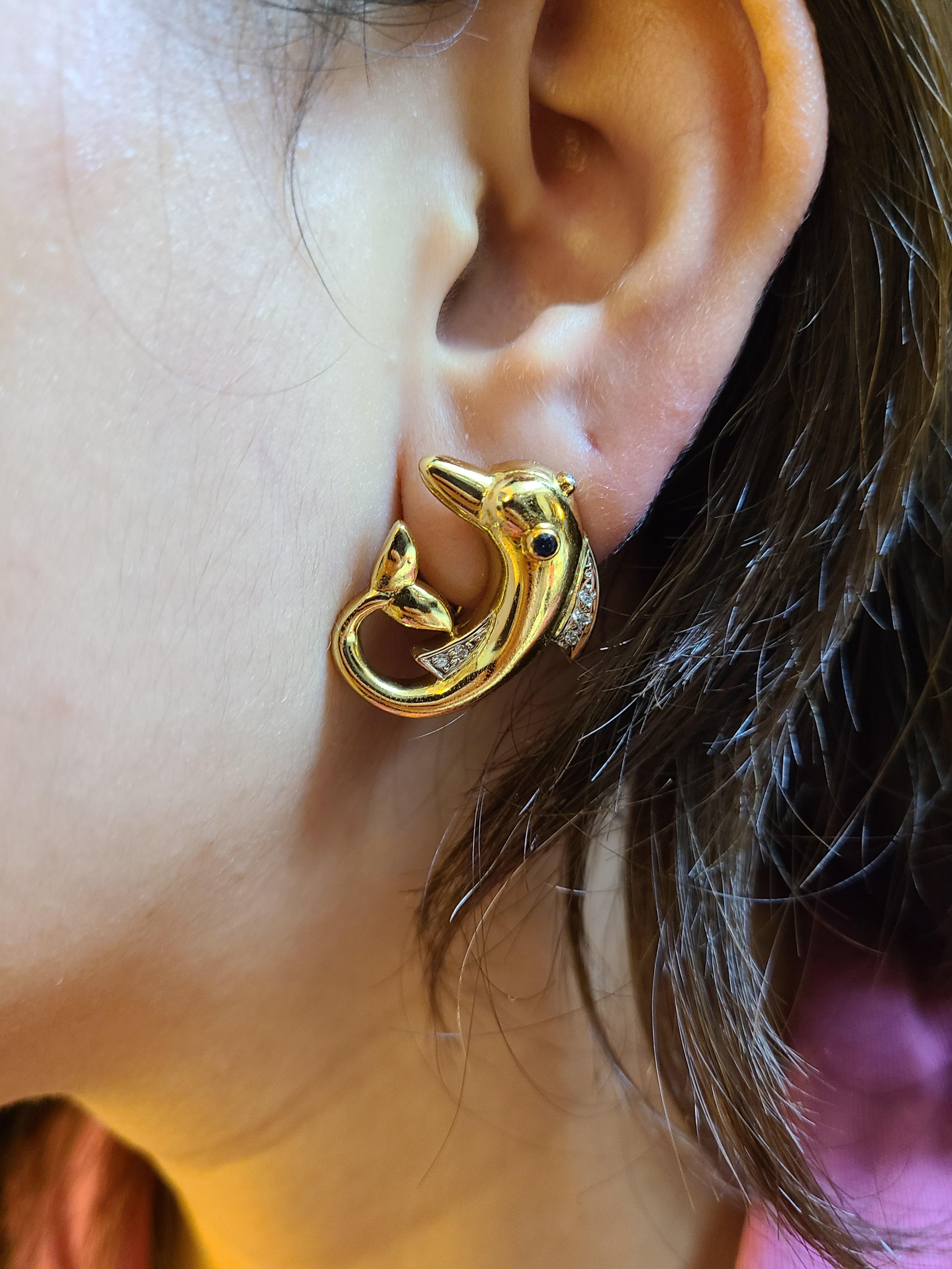 A Pair of Designer Dolphin earrings made in 18K gold by Alen Dione (Marked) with Diamonds . The gross weight of the earrings is 15.5 grams with 10 pieces of diamond. The earring dimension in cm 2.5 x 2 x .3 (LXWXD). These are clip on studs , can be