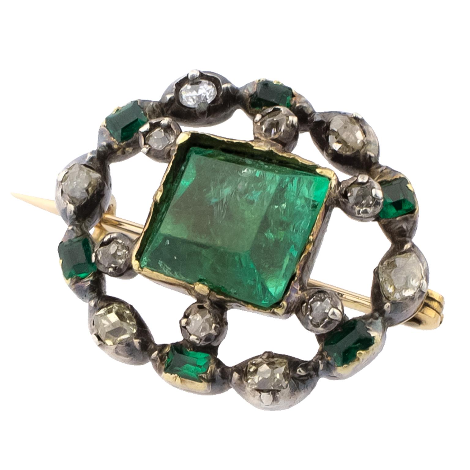 Early 19th century brooch in silver-topped gold centered by a table cut emerald, surrounded by smaller diamonds and emeralds.
Dimensions: 23 x 18 mm (0.91 x 0.71 in)