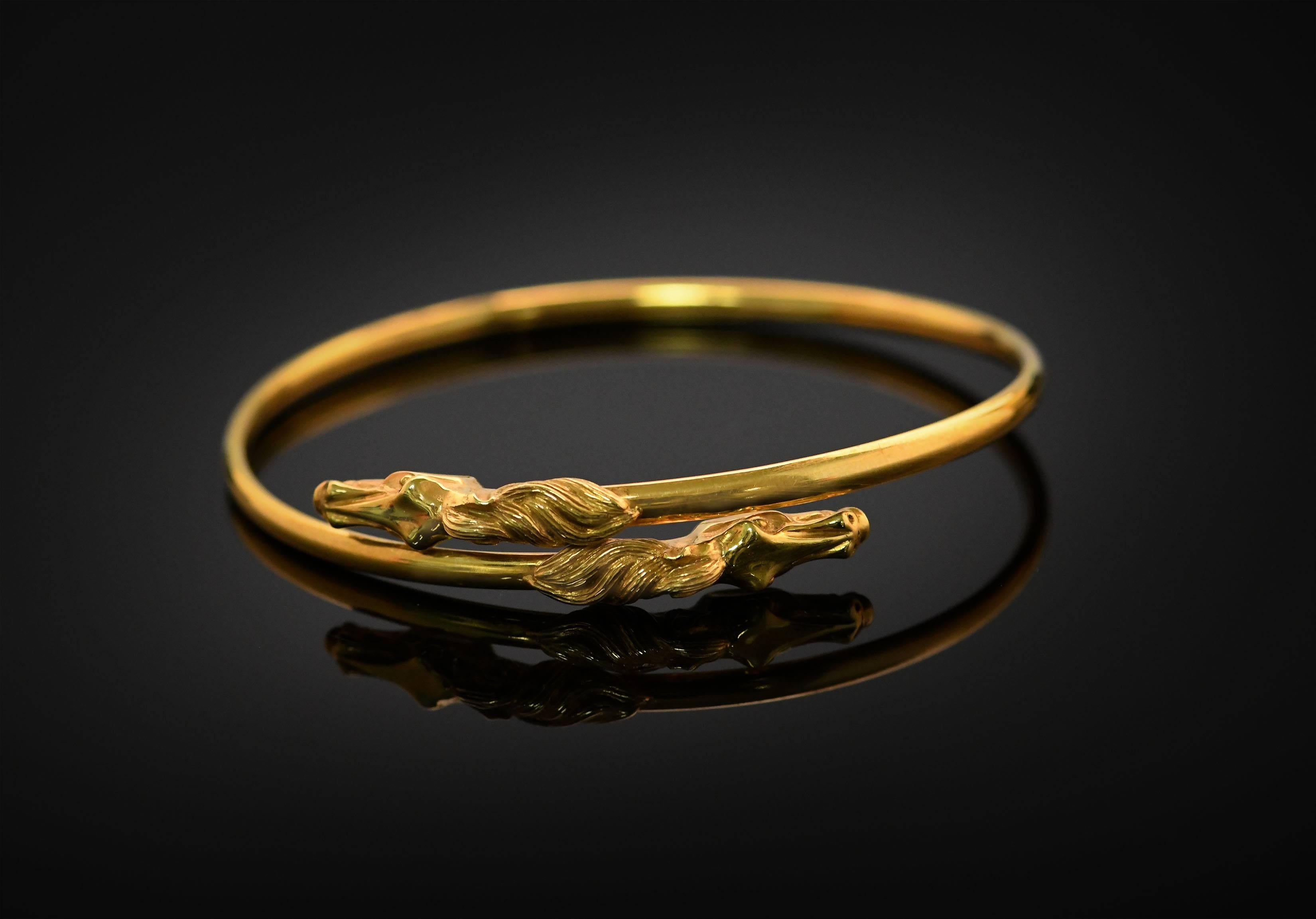 This bangle is made in an Art Nouveau style. The horse's heads thrust forward in the thrill of speed. The flowing manes add to the feeling of movement and speed. The lines and contours of the heads lend the bangle a sinuous beauty. 

This is