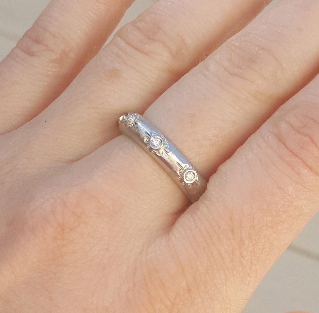Adriana is an utterly modern ring, with old world sensibilities. The diamonds in clean bezel settings stand out against the delicately engraved surface of the band.

This is an eternity style of diamond band, and it's a great size either on its own