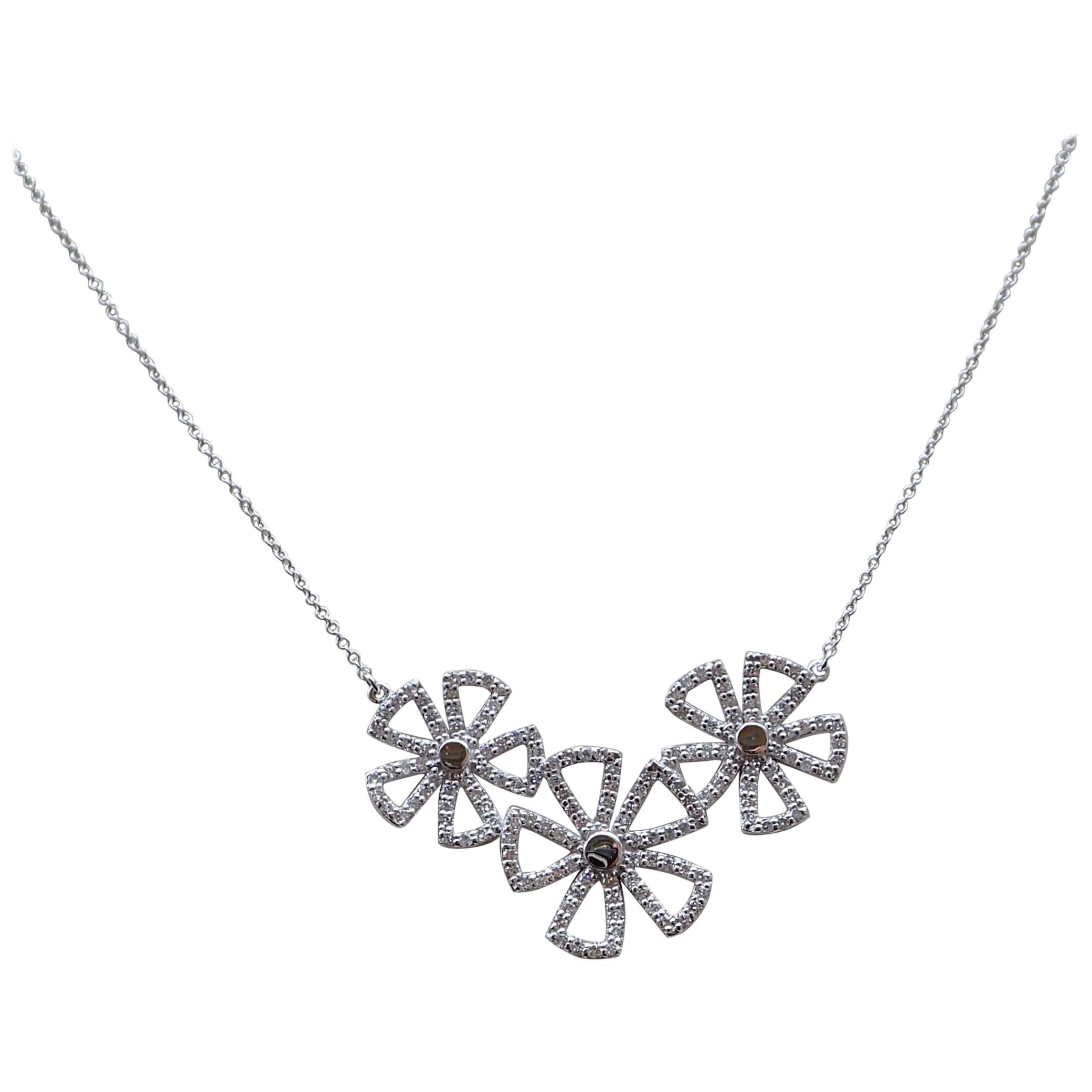 An 18k white gold necklace is 17 1/2” in length and contains a three flower cluster which contains one hundred and fifty-six Round Brilliant Cut diamonds that measure 1.2mm and weigh a total of 1.12 carats with Clarity Grade VS and Color Grade G.