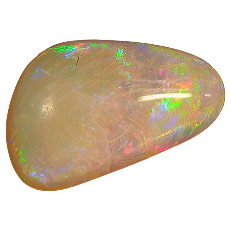 This stunning piece features an 18-karat gold setting that elegantly showcases a free-form Australian opal, renowned for its captivating play of color. The opal displays vibrant hues of blue, green, and orange that shift beautifully in the light,
