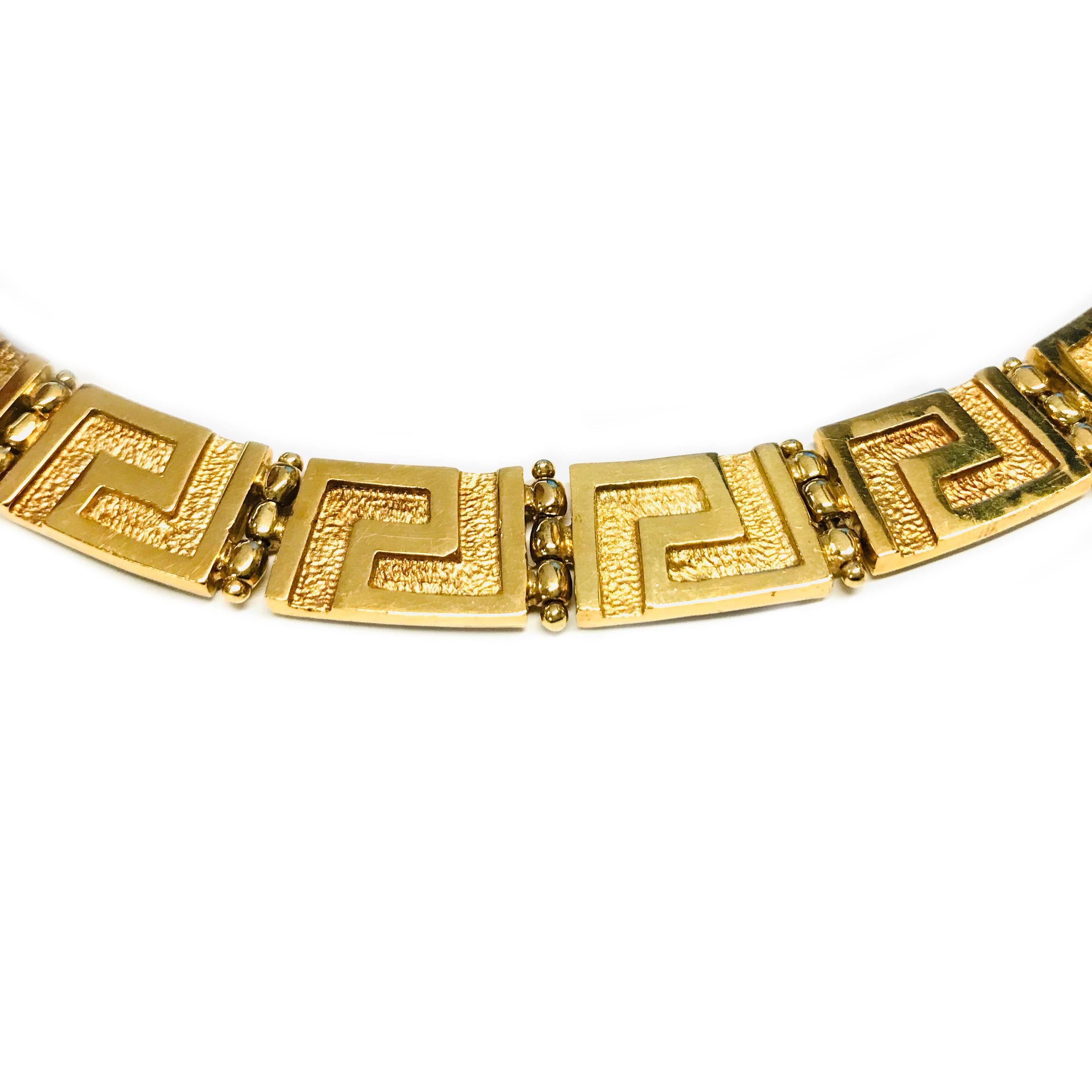 collier à méandre grec en or 18 carats. Le collier est composé de motifs rectangulaires en or en forme de clé grecque et de perles en or articulées. La largeur du collier est de 11,3 mm. Le nom JBG est gravé en script au dos du fermoir, avec un