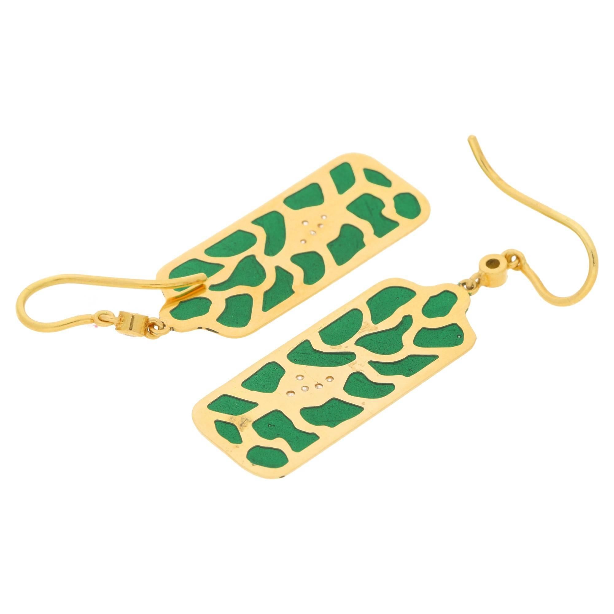 Estimated total diamond weight: 0.16cts.
An unusual pair of 18ct yellow gold plique-a-jour enamel and diamond drop earrings. With a large panel of 18ct yellow gold with cut-outs filled with green plique-a-jour enamel and one with five pave set round