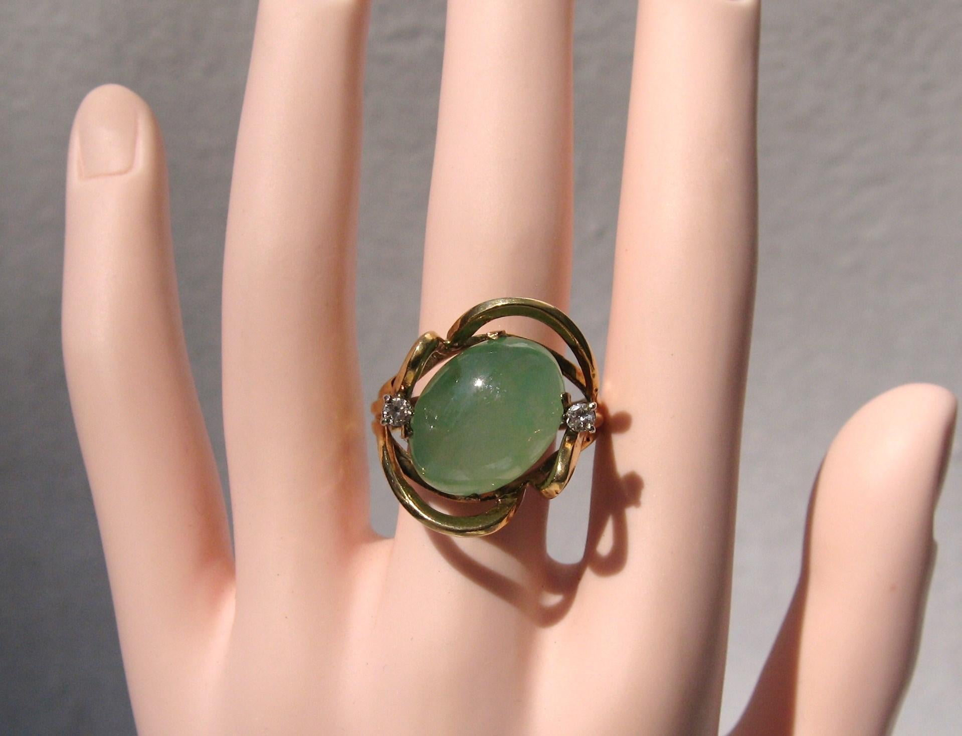 Stunning 18K gold Green Jade & Diamond Cocktail ring. Large center jade, measuring 17.5mm x 13.6mm x 7.75mm. Approximately 15 Carats. Diamonds are accents at about .5 points each. The ring has a sizer inside of the band that allows several sizes to