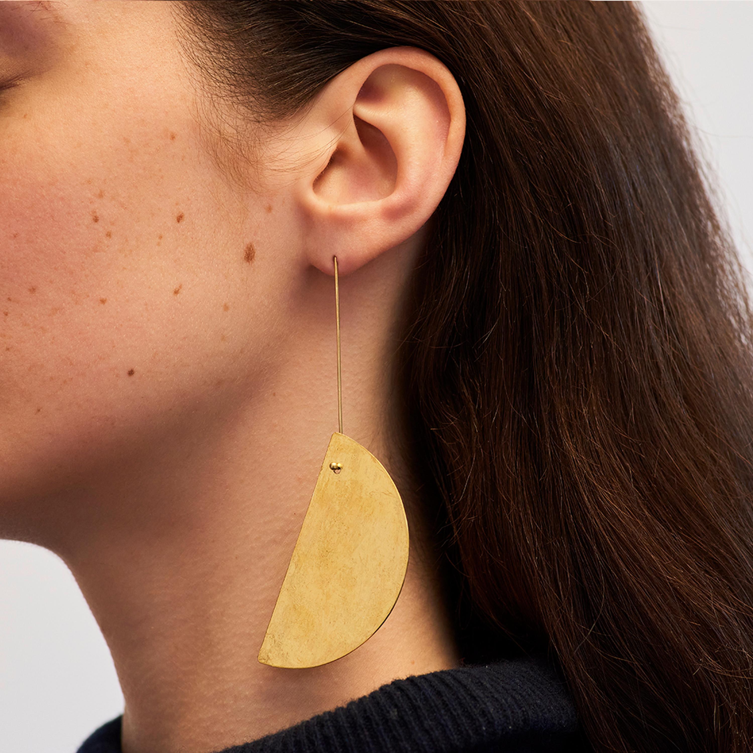 Catherine’s Half Moon earrings are reversible, with a delicate texture. Their half moon forms are silver on the front, and coated in gold leaf on the reverse side. The ear post are made form 18 karat gold.

Half-disk height: 59 mm
Total height: 102