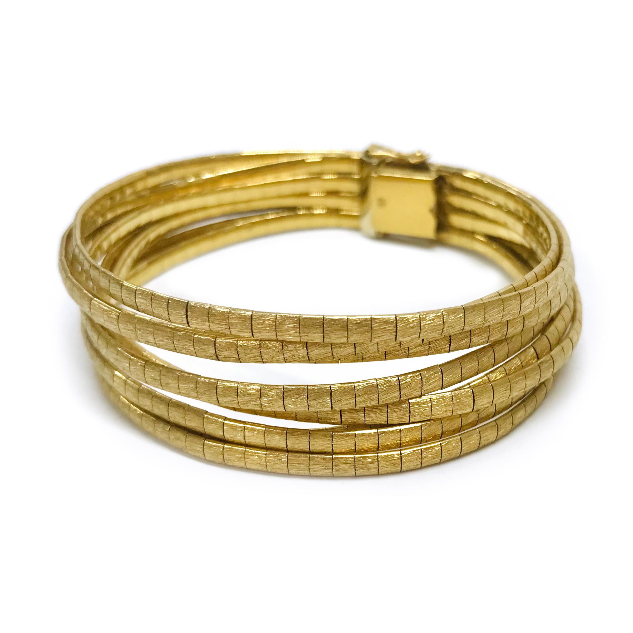 18 Karat Gold Vintage Eight-Strand Bracelet. The bracelet features a large clasp that closes two layers of strands of liquid-like gold threads, each is made from small squares. The top is Florentine finish and the underside is smooth. On the clasp