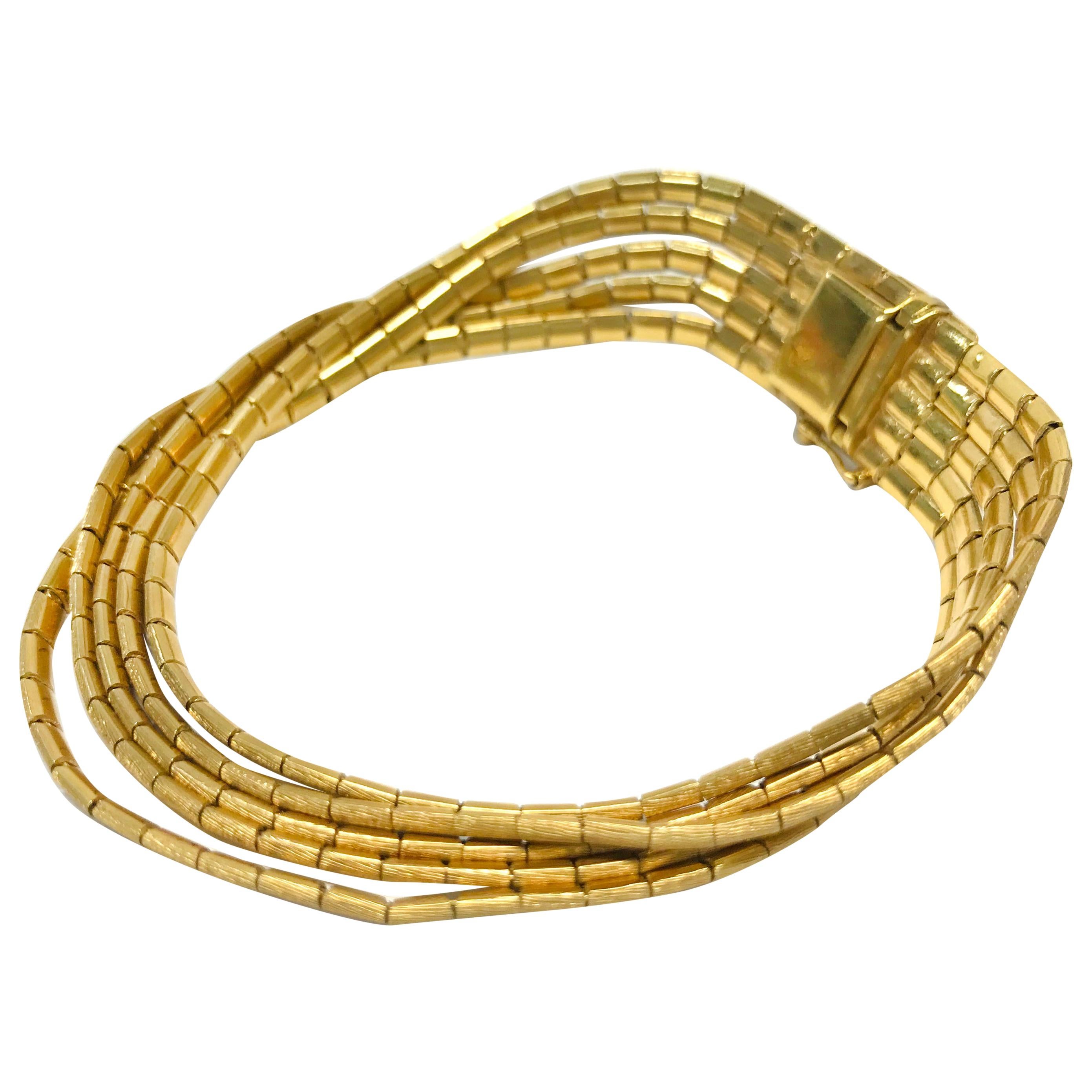 18 Karat Gold Vintage Five-Strand Bracelet. The bracelet features a large clasp that closes five strands of liquid-like gold threads, each is made from small rectangles. The top is Florentine finish and the underside is smooth. The bracelet is 0.52