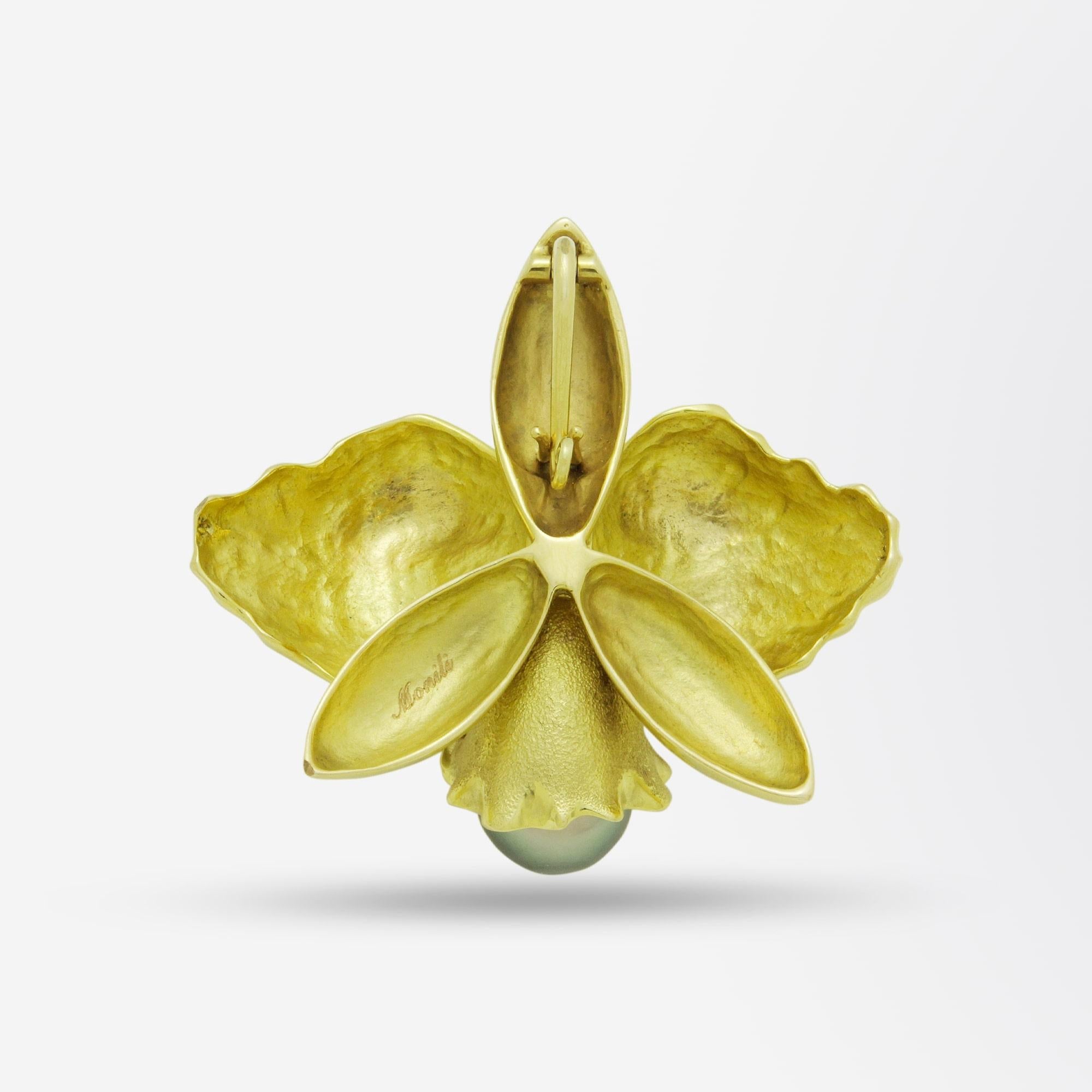 An 18kt yellow gold and Tahitian pearl enhancer pendant in the form of a large orchid. The pendant has a secure hinged bail at the rear, allowing the piece to be clipped over a strand of large pearls, or be used on a chain as a pendant. The gold has