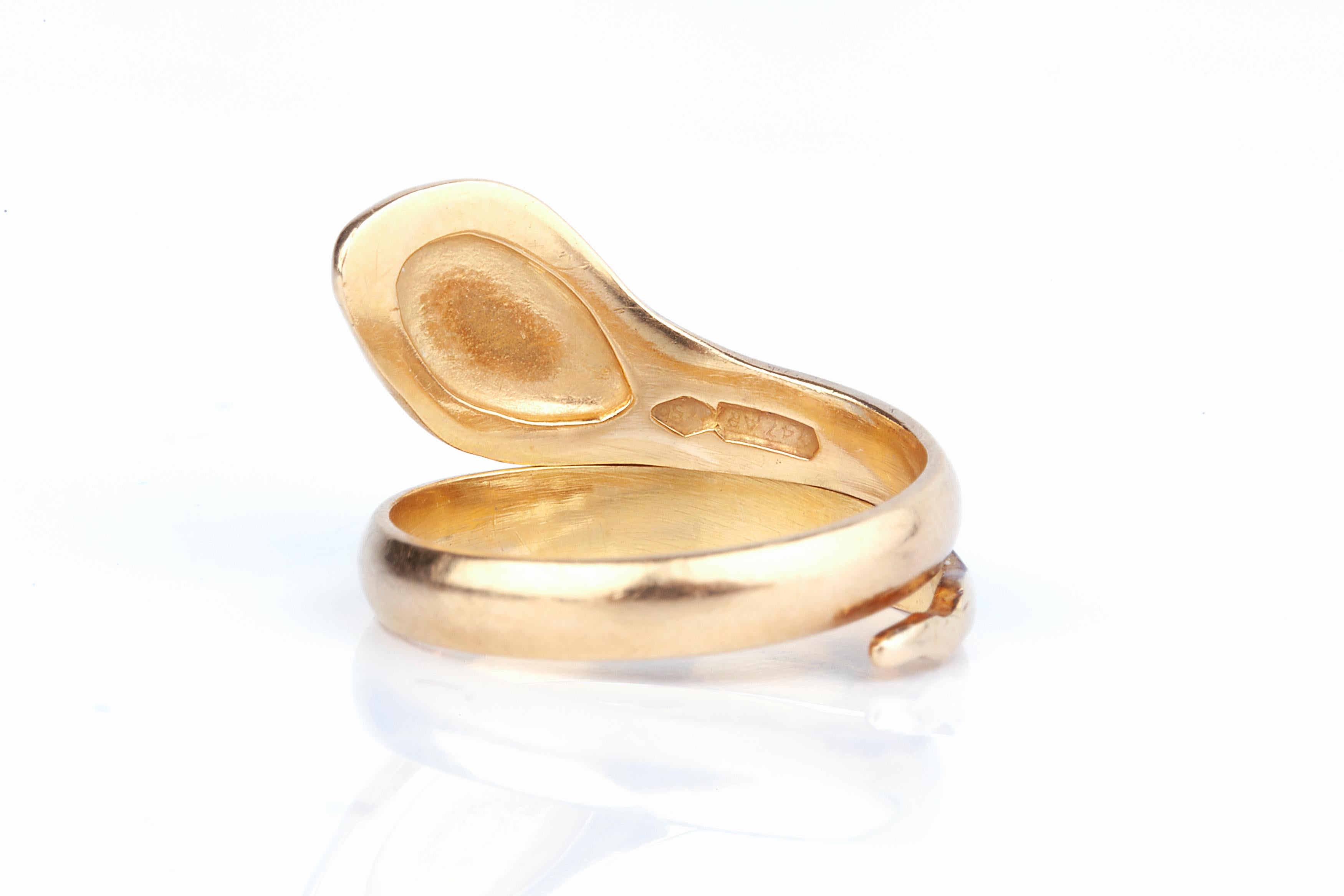 An 18k gold snake ring in the form of a simple snake coiled around the finger.  The ring is hallmarked for 18k gold and is size US 4 1/2