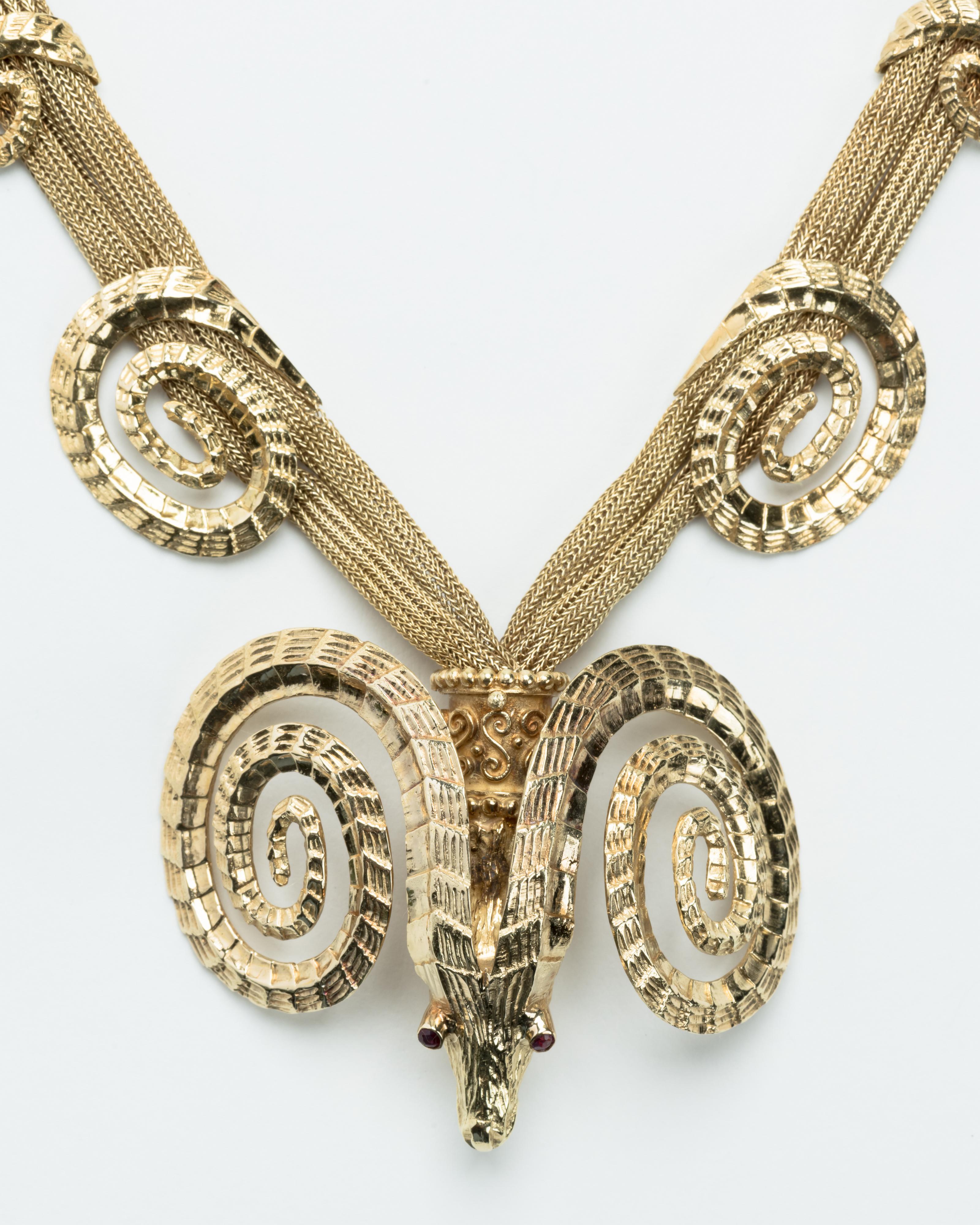 18 Karat rams head necklace with two detachable bracelets. The necklace has beautiful double stranded woven chains with decorative rams horns. The bottom of the chain has a stylized ram's head with 2 small ruby eyes.. The necklace has superior