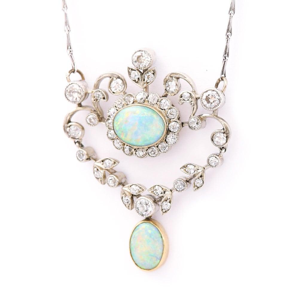 A beautiful original Edwardian opal and diamond pendant created in the garland style, circa 1910. During this period jewelry became far more delicate in design as techniques improved for diamond cutting and setting. These old European cut diamonds