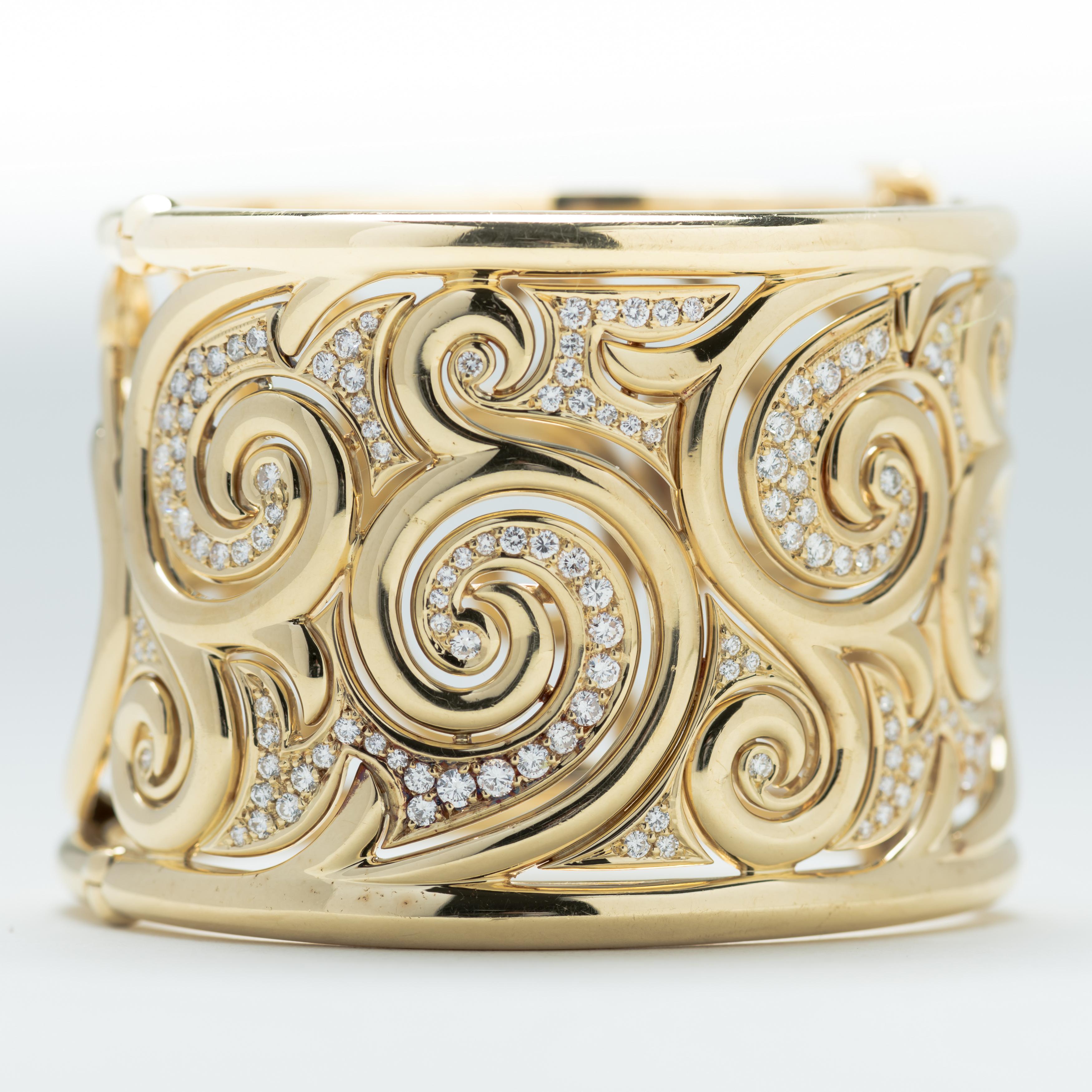 Beautifully made 18 karat gold cuff bracelet with scrolled design inset with diamonds on the front and open scroll work on the back. Stamped 750, hallmarked with the initials 