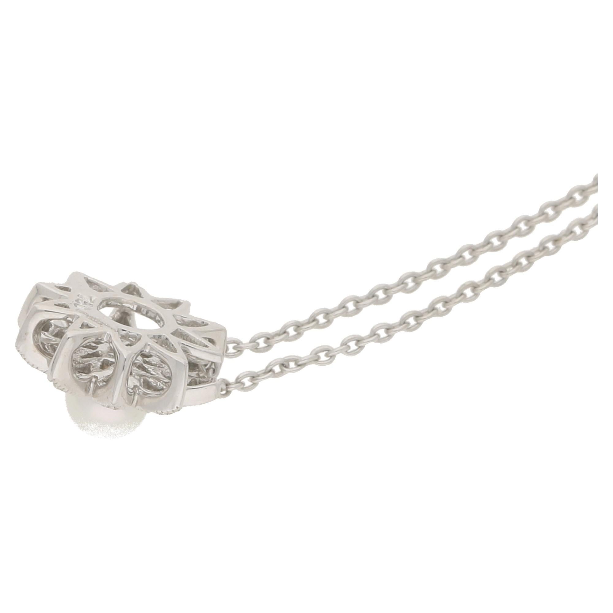 A contemporary and very chic floral pendant with a central pearl surrounded by brilliant-cut diamonds totaling 0.08ct set in 18ct white gold suspended on a 16 inch white gold chain which is included with this item.