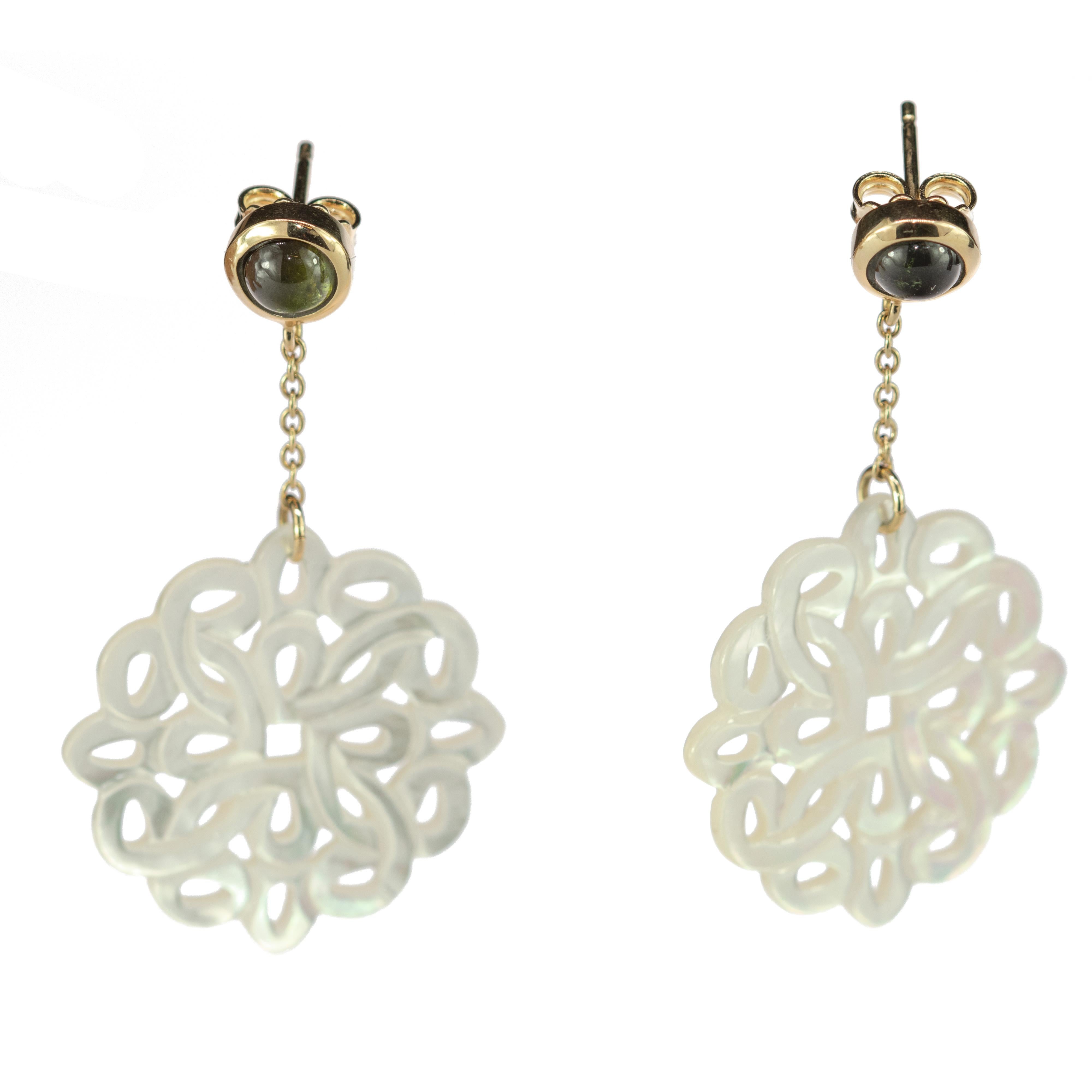 Green peridot dangle earrings connected to a delicate 18 k gold chain that ends in a perfectly crafted round mother of pearl design evoking the details and italian history across the whole shape.

This design is inspired by the Greek jewelry. In the