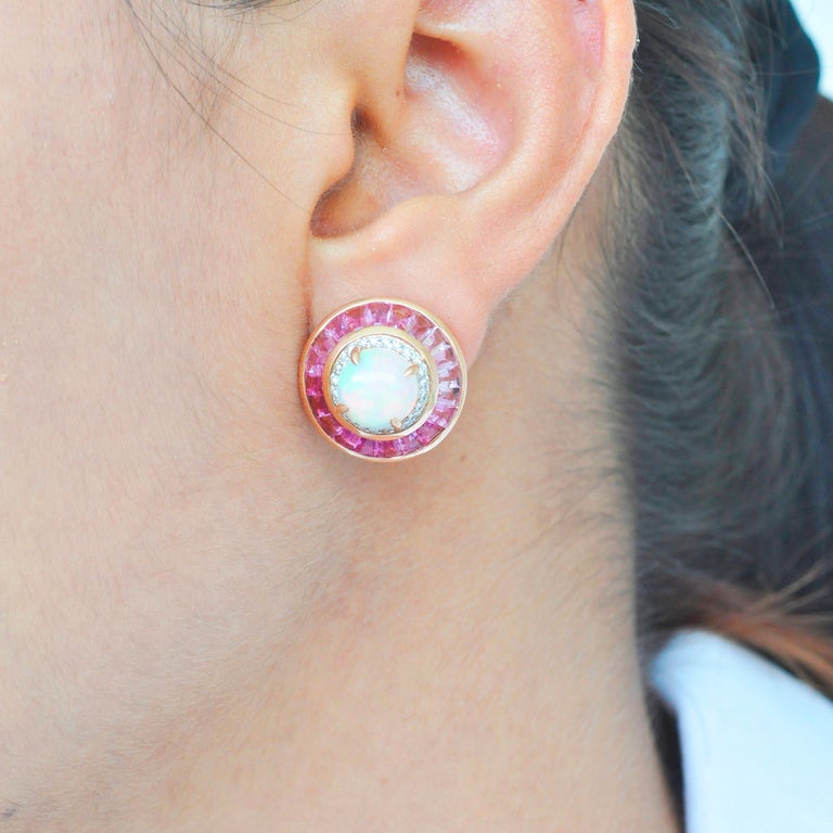 18 karat gold pink tourmaline ethiopian opal diamond circular stud earrings. 

With spectacular hues in each stone, this 18 karat gold pink tourmaline ethiopian opal diamond stud earrings are a treat for the wearer. Hand picked selections of