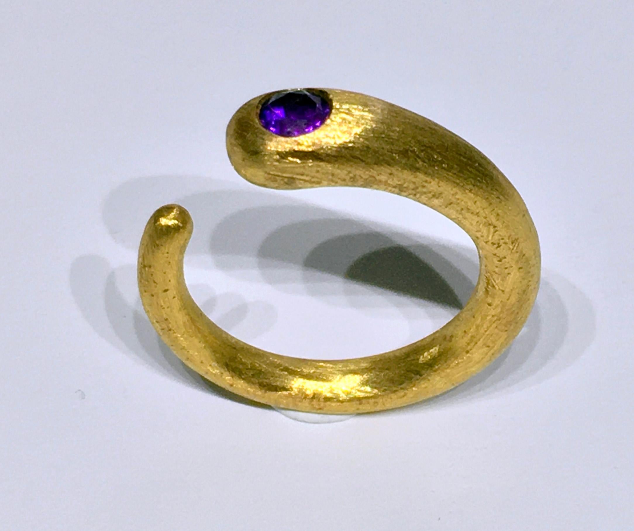 An 18kt Gold Plated Silver Ring, Set with an Amethyst with a Brushed Finish. The Ring is a size 7.25 US and is Curl Style, to easily adjust to a similar ring size. This Ring is 6.5 Grams of Gold Plated Silver and set with a 0.34 Carat